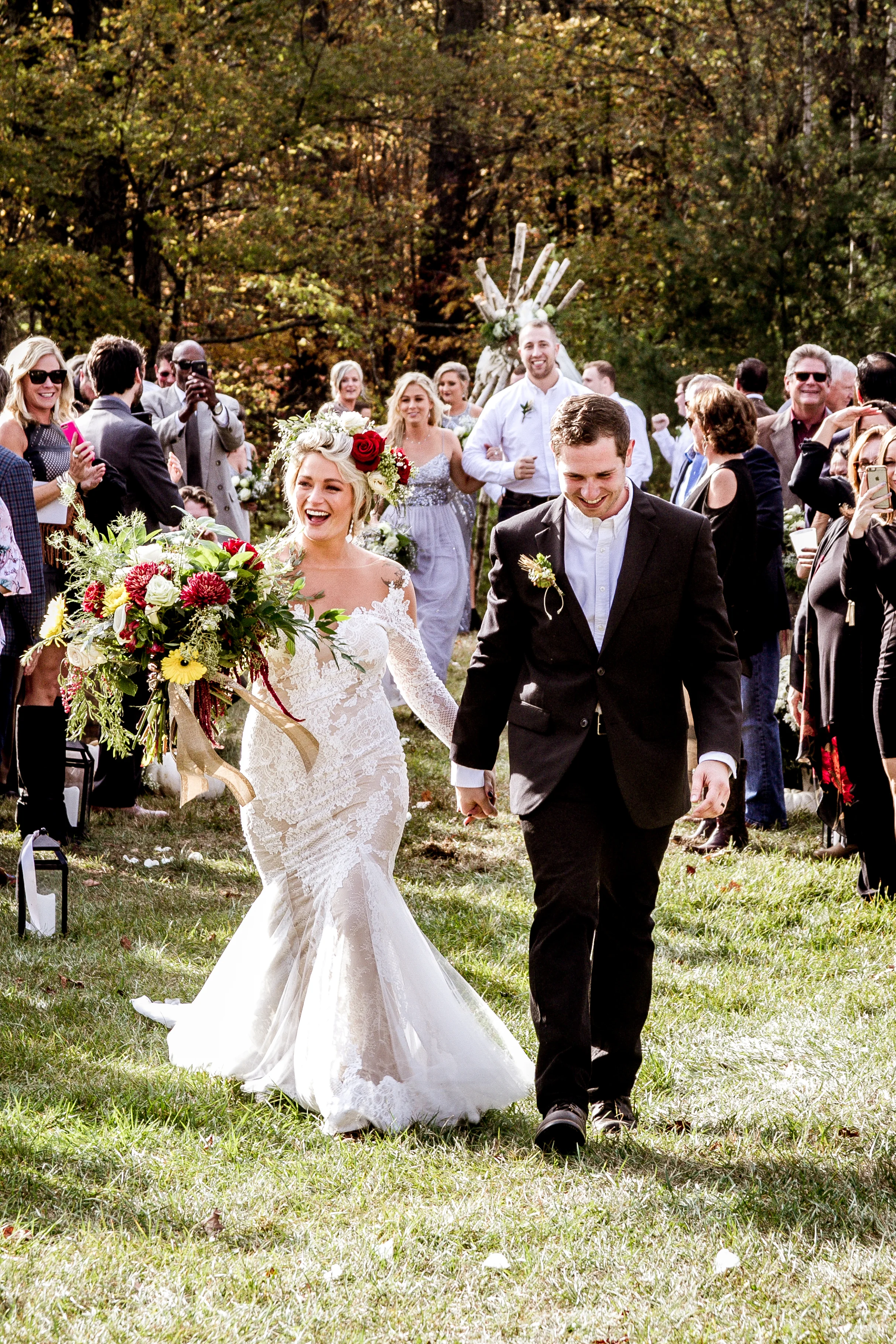 In this picture, we can get a clearer idea of the bridal party behind Lexee and Brandon. Lexee's bridesmaid is wearing a dress that has a fairy tale feel to it. The groomsmen is wearing black dress pants, with a white dress shirt.