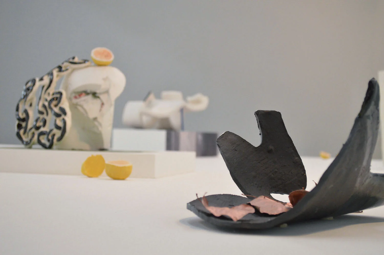 Lotta Lives in a Garage , hydrocal, newspaper, flashe paint, flocking, photographs, glazed ceramic, 10 x 14 x 9.5 inches Mulholland Drive (Inverted), glazed ceramic, leaves, spray paint, 6 x 9 x 13 inches