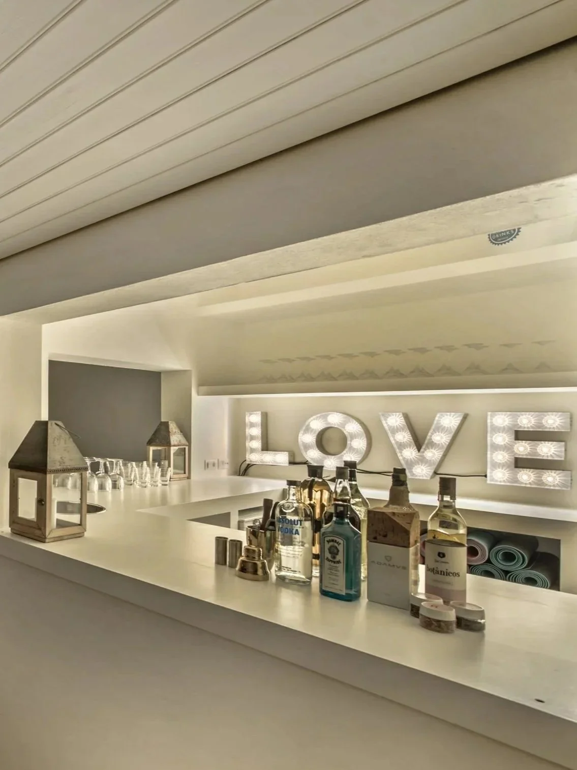 The rooftop pool bar at Casa Fuzetta at night; the white bar with its LOVE marquee lights, spirits and lanterns.