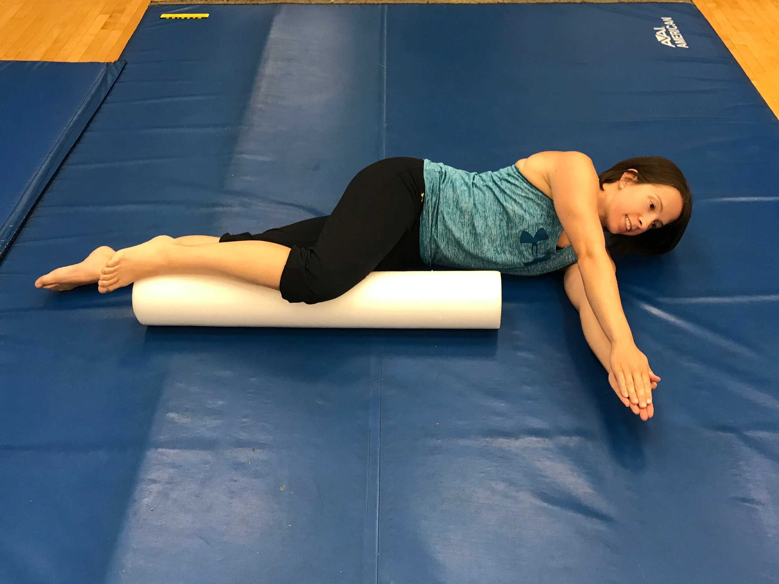 Starting position: Begin on your side with a foam roll under the top knee as shown. With the arms together, extend them out directly in front of you.