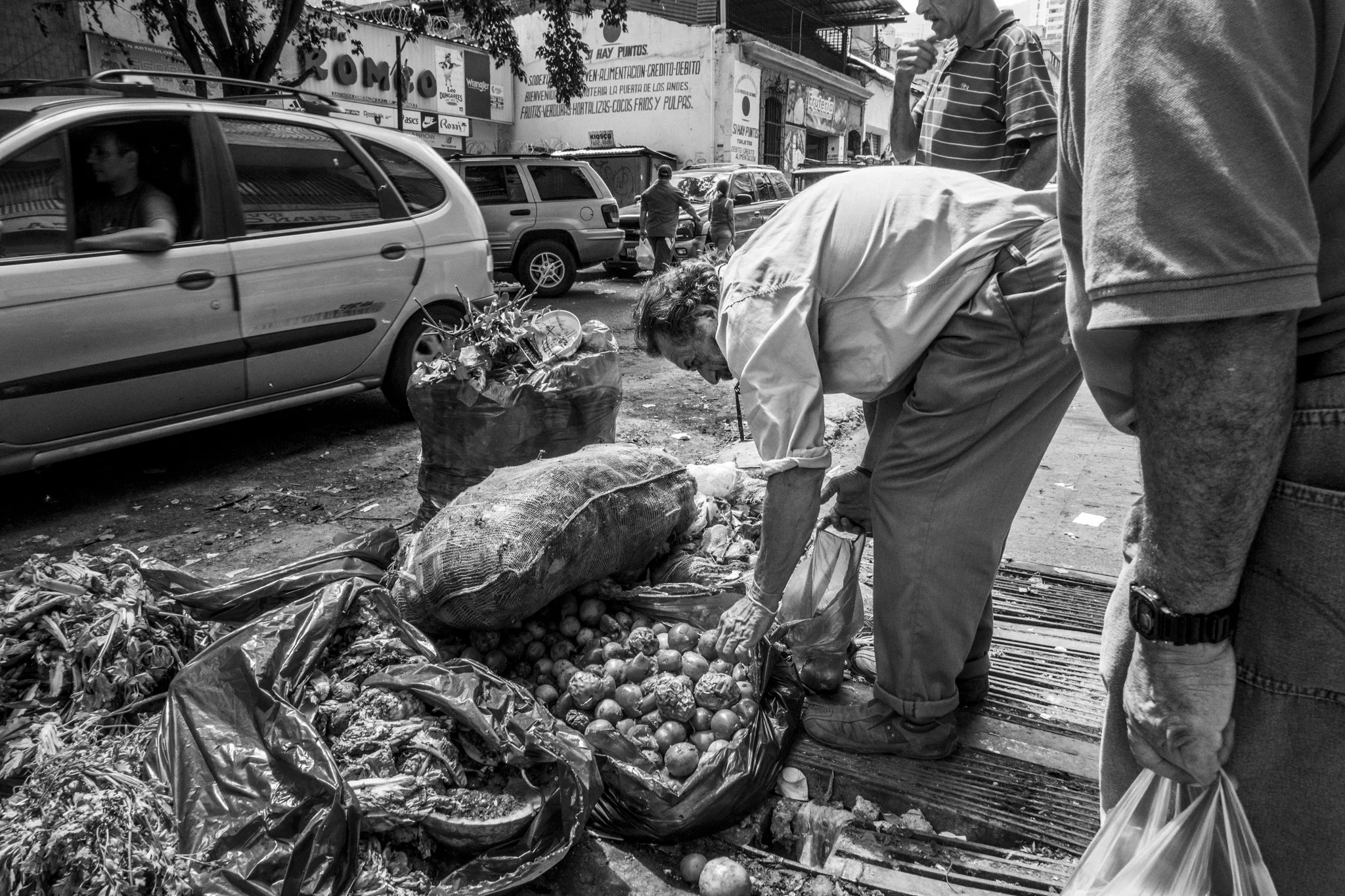  An old man picks up some tomatoes and fruit discarded at the end of the day by a green grocer. Inflation has a strong impact on food prices, and a bag of tomatoes can easily reach the equivalent to one day's minimum wage.&nbsp; 