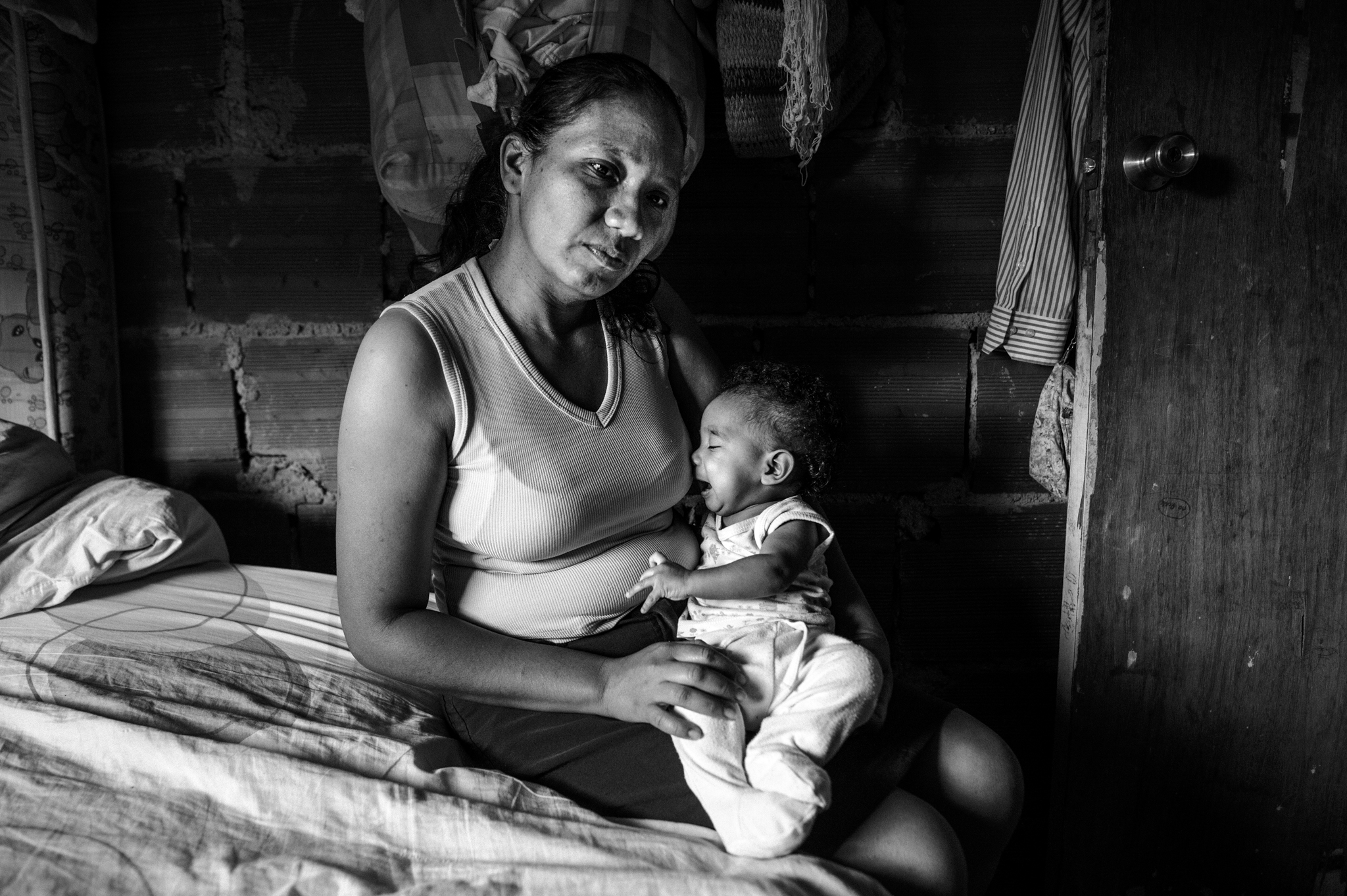 Jaqueline, 33, sits on her bed with the little Sinay, just four months old.&nbsp; Because of poor nutrition, the mother has no breast milk and artificial substitutes are only available through food smugglers (bachaqueros) that sell a can of milk pow