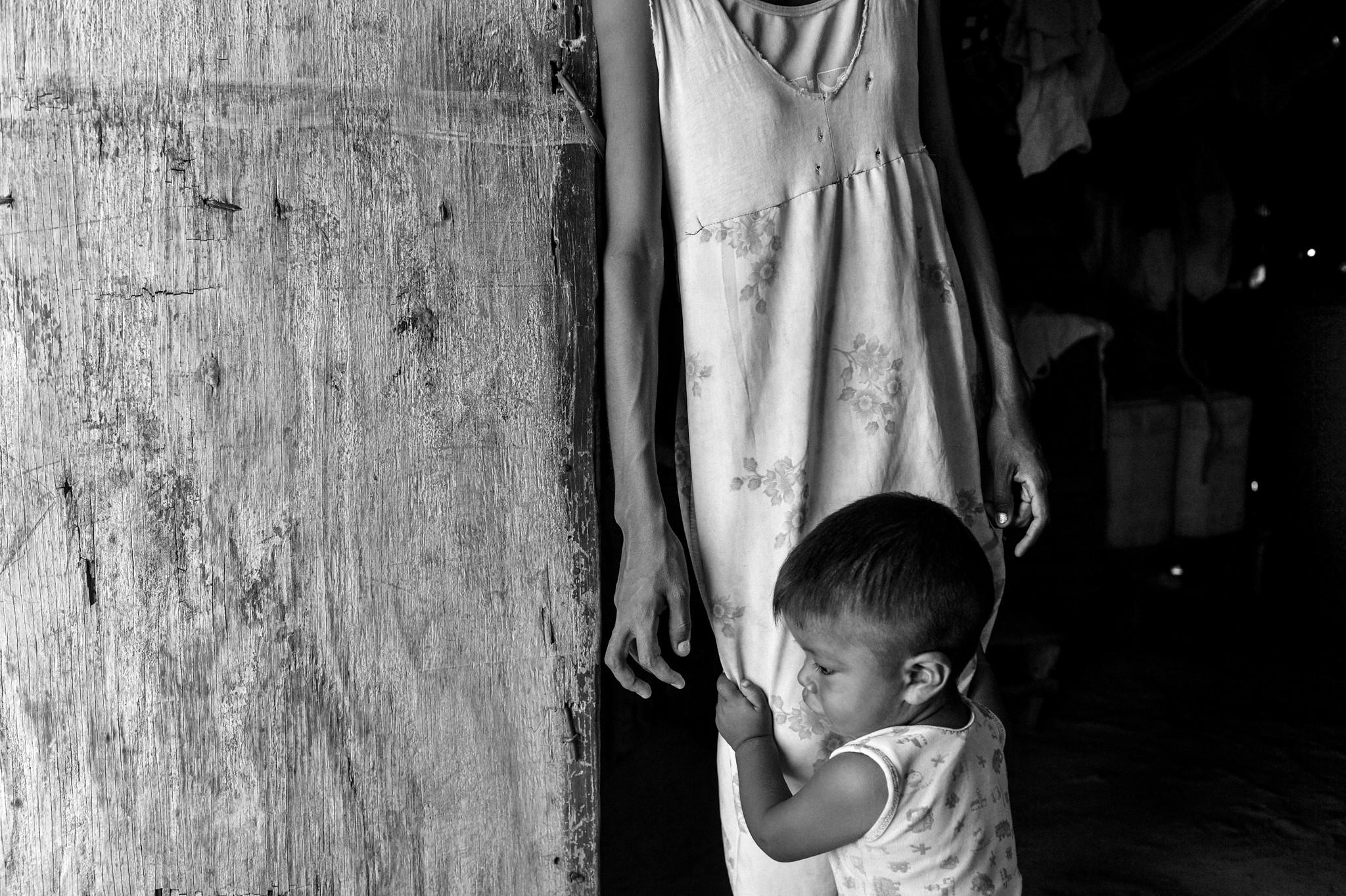  The little Josué David, 1 year old, tightens the dress of his mother Aura Rosa, 22 y.o.&nbsp; The mother says she's not eating every day in order to feed him properly. &nbsp;&nbsp; 