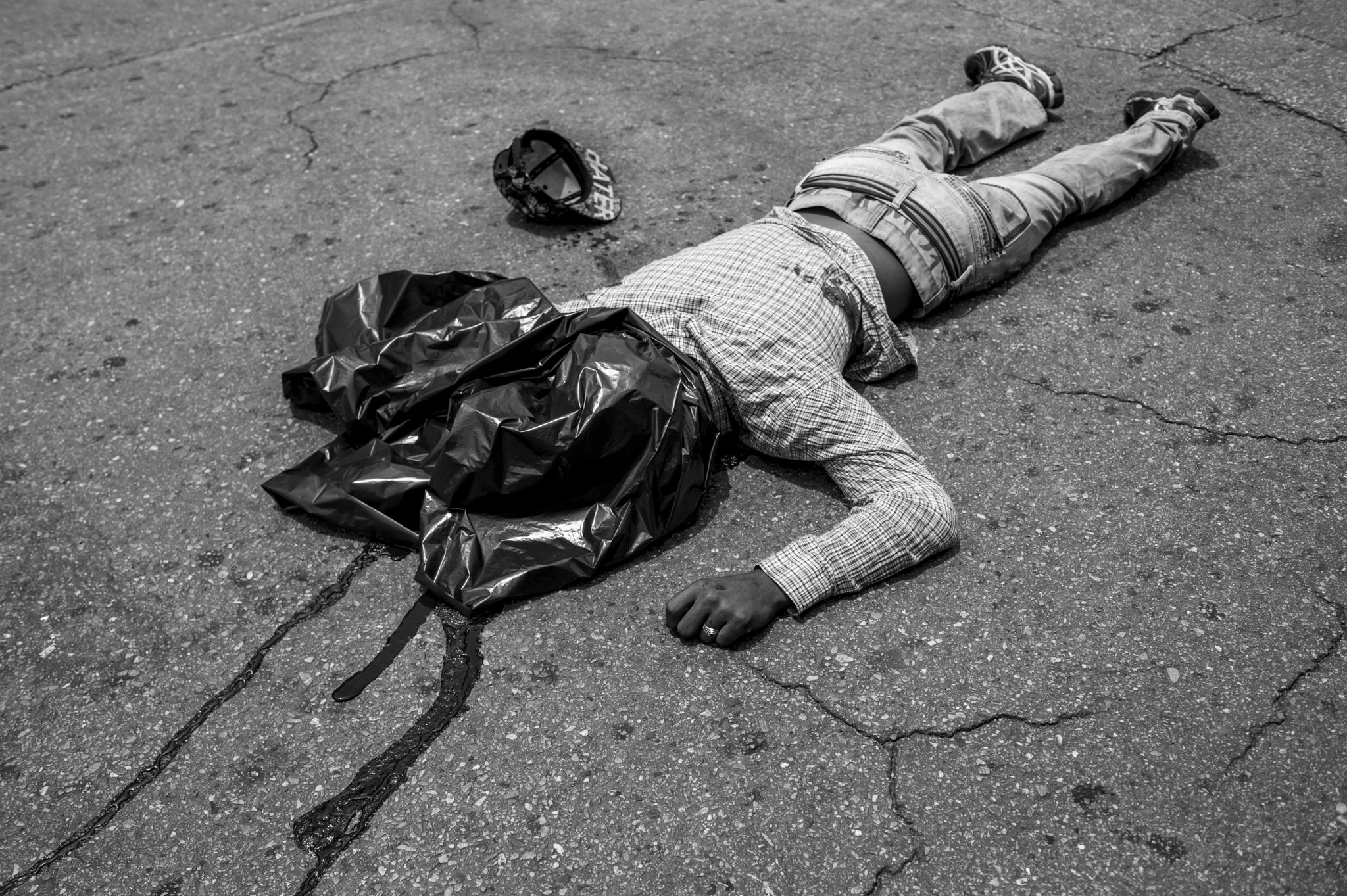  A young man lies dead in front of a supermarket where he allegedly just tried to rob a man, who reacted by shooting him in the stomach. 