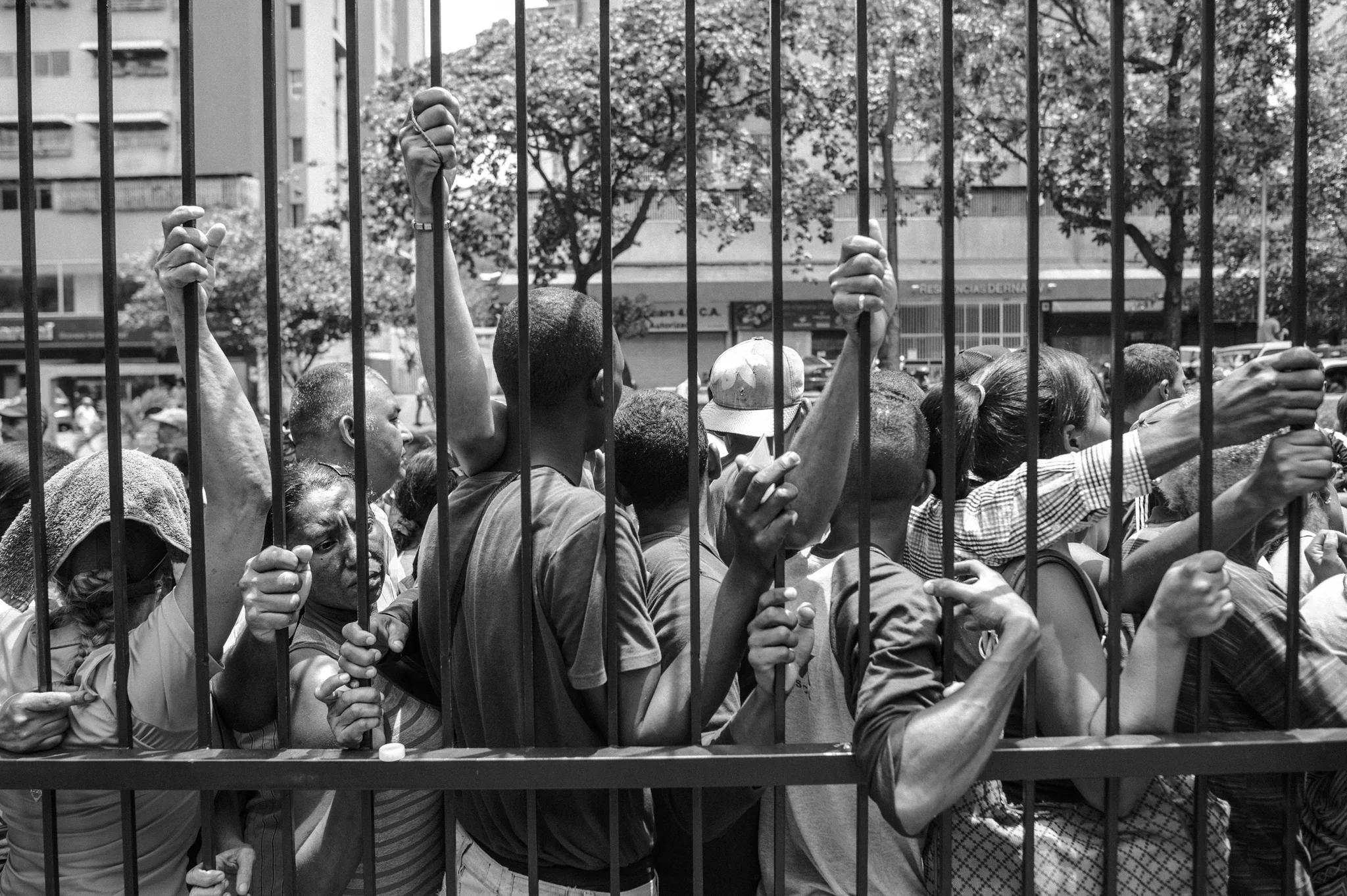  People line up under hot sun in order to buy basic products in front of a supermarket in La Urbina district.&nbsp; 