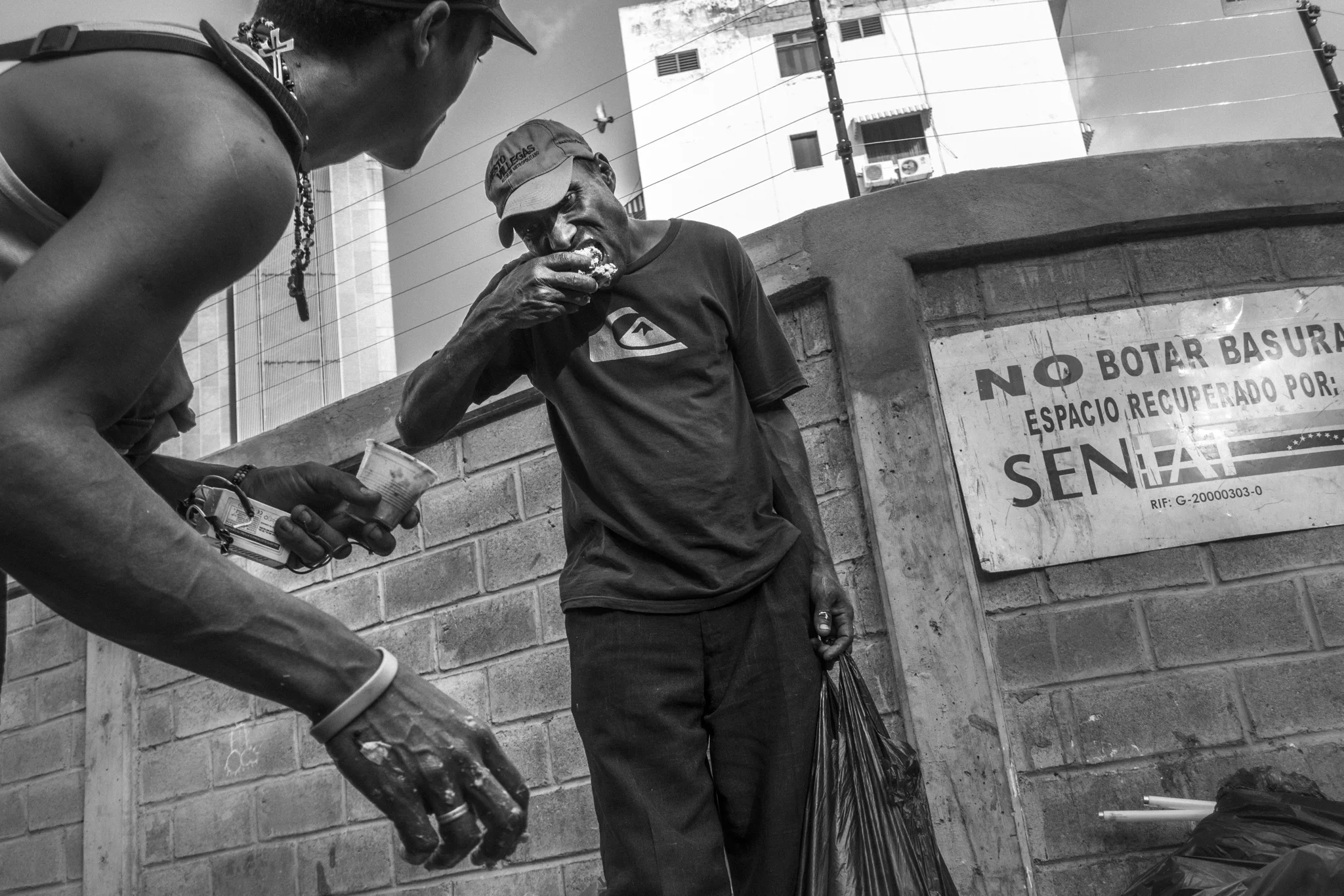  Two people eat the food they find amid the rubbish at a district full of restaurants in downtown Caracas.&nbsp; 