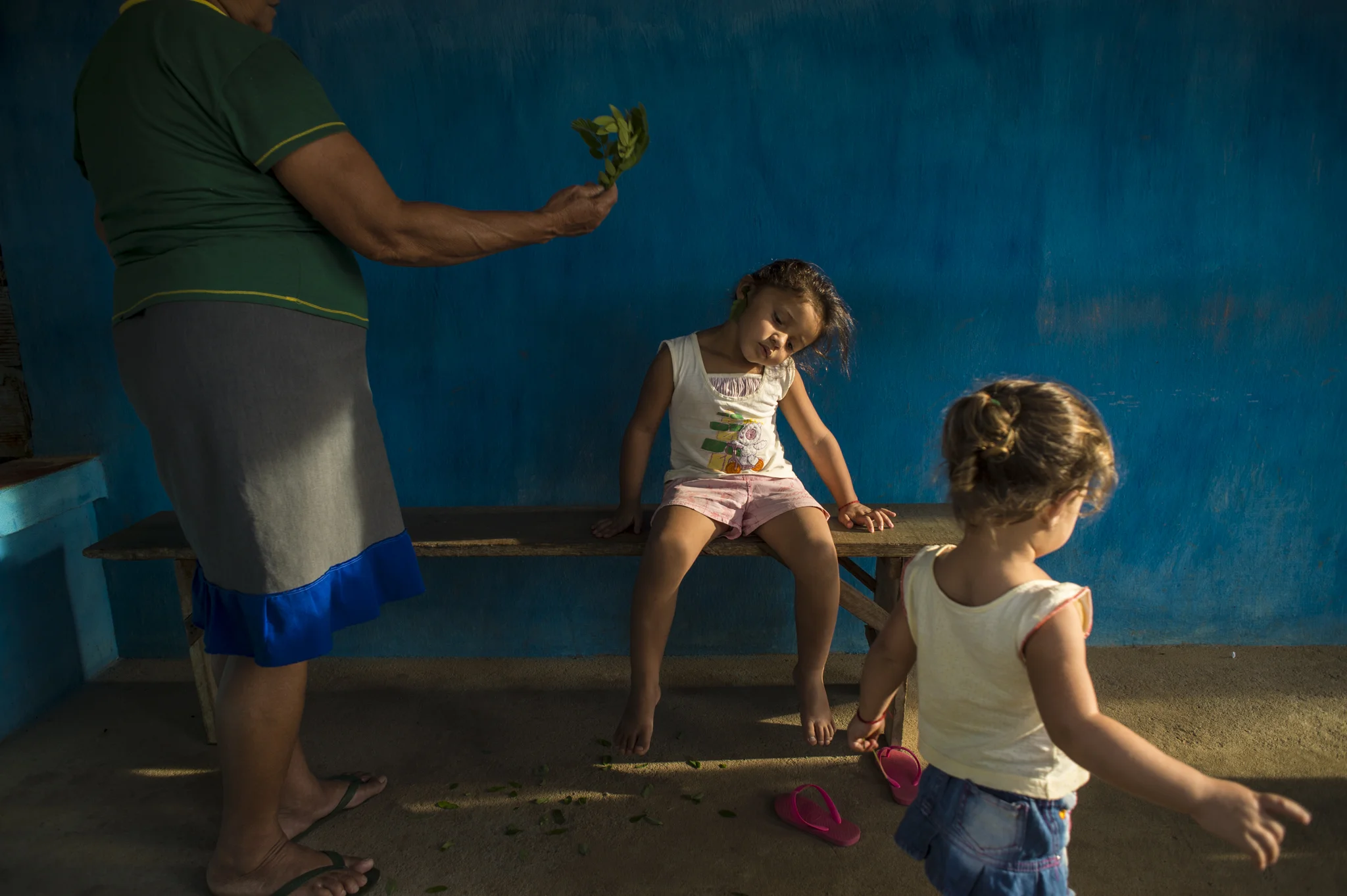  A little girl receives a blessing on the doorstep of Expedita's house, a folk healer who treats dozens of families each day, near Exù, Brazil. Her services are free and she is deeply respected by the locals.&nbsp; 