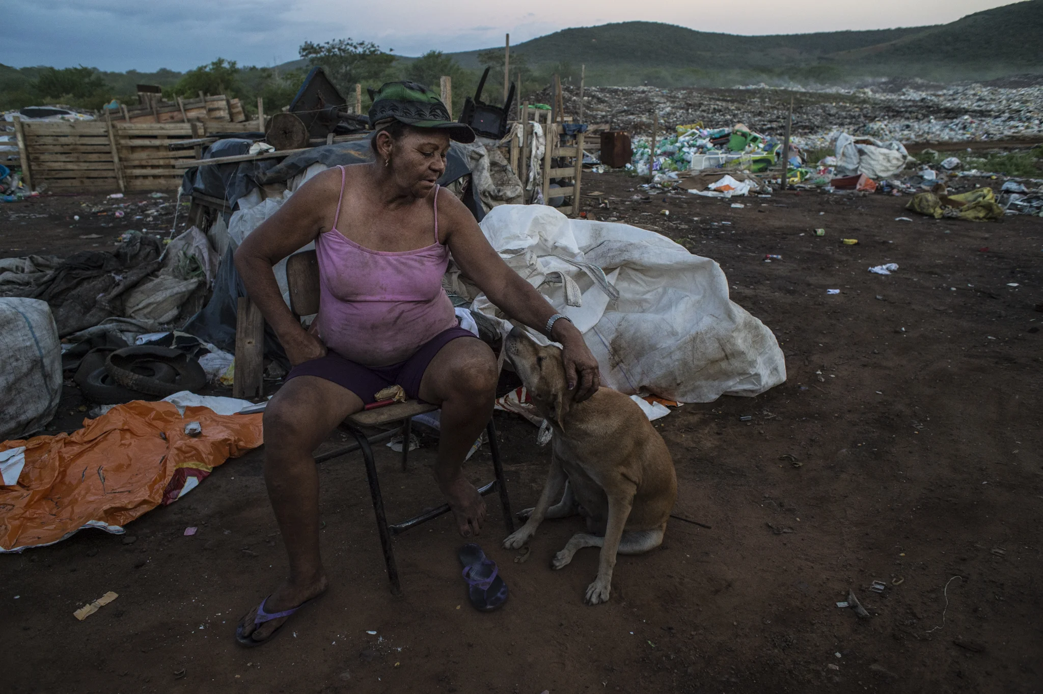  A woman is seen caressing one of the many dogs in the illegal dump where he lives for a few weeks, close to Serra Talhada, in the Sertao Pernambucano, Brazil.&nbsp; 