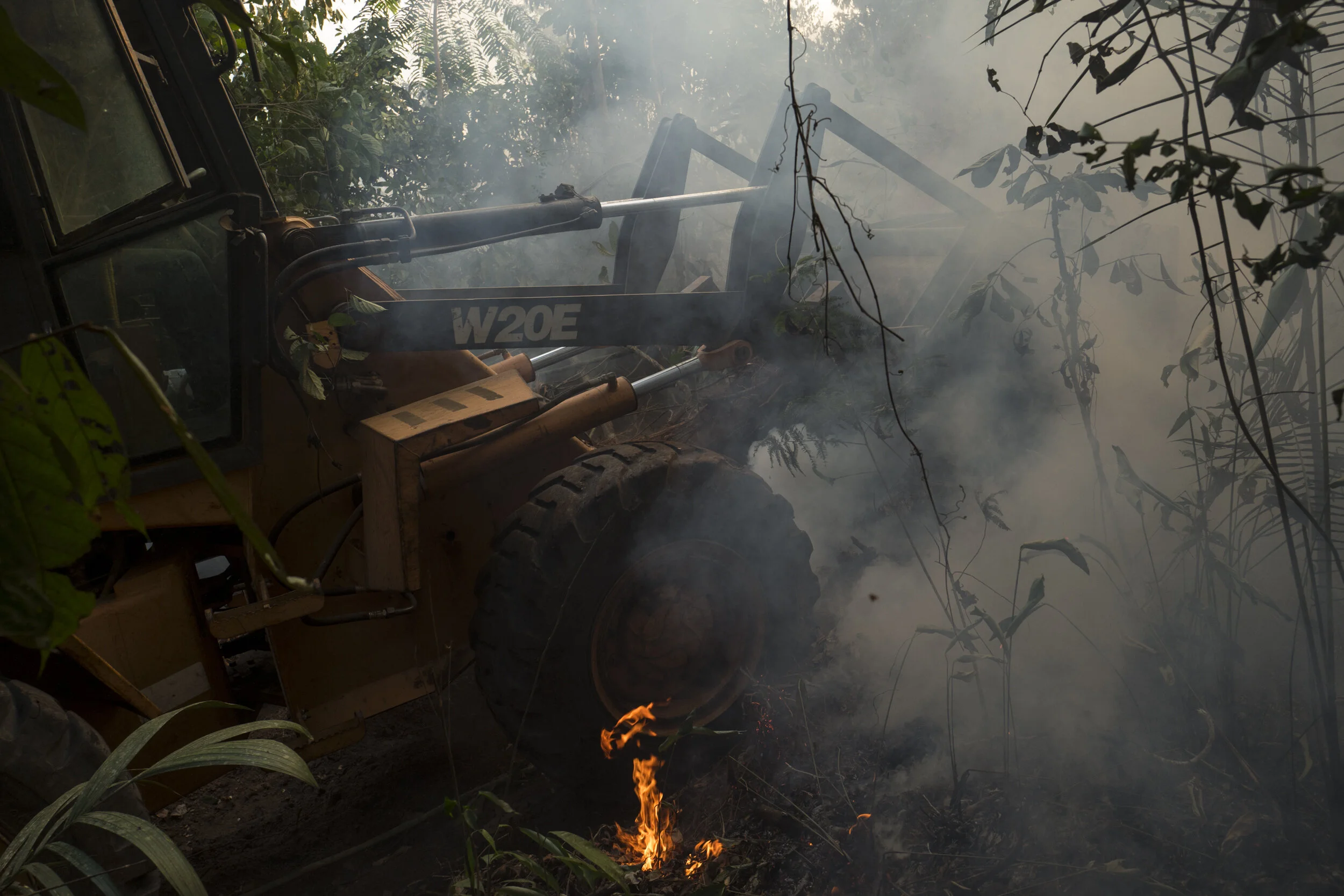  A man working on a wheel loader tries to contain a fire, supposedly hanged by unknown in a small portion of rainforest at the edge of a street near Porto Velho, Brazilian Amazon. 