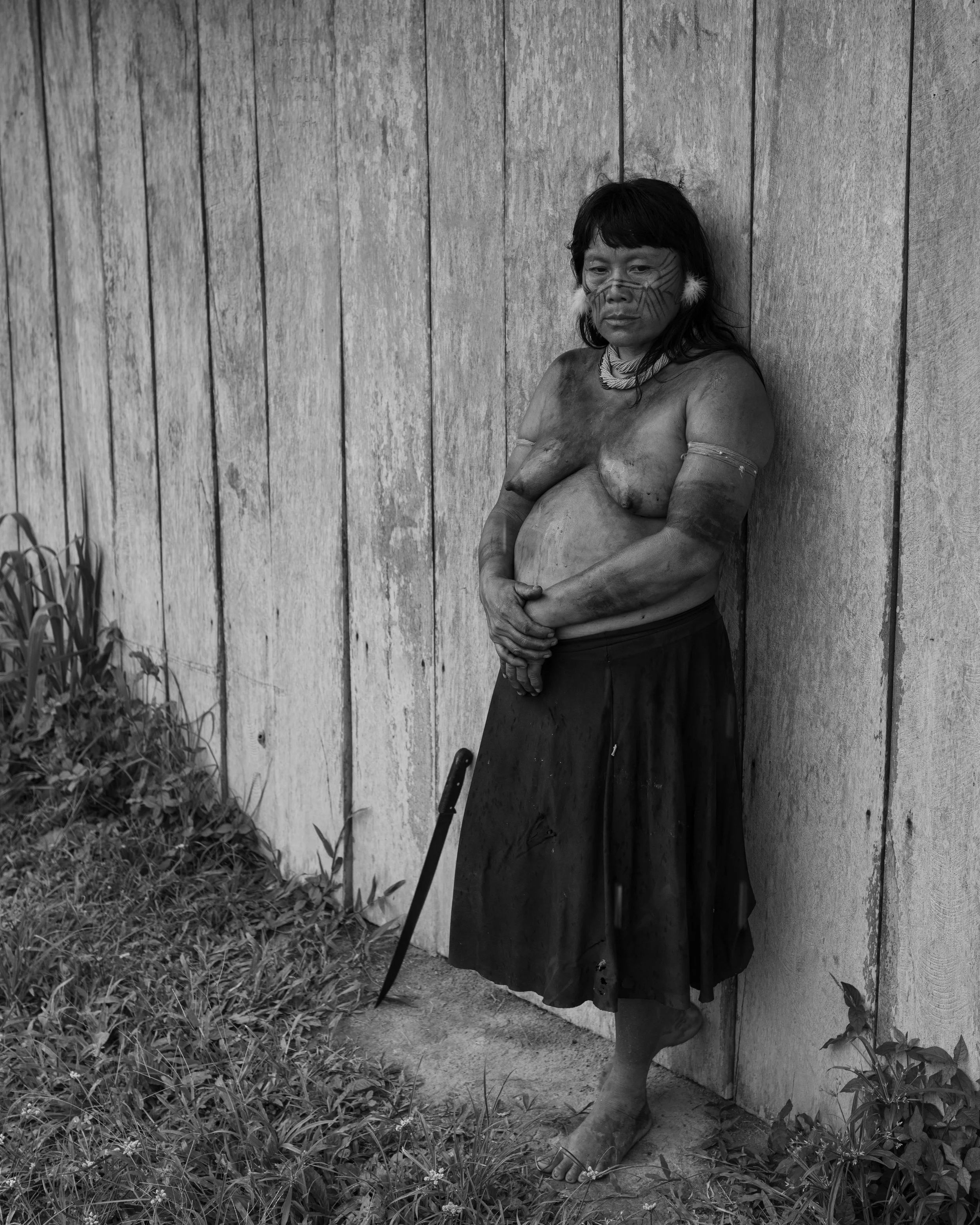 A Yanomami woman observes the banks of the Uraricoera River, where the Palimiu villagers have been ambushed by armed illegal miners on May 10th.