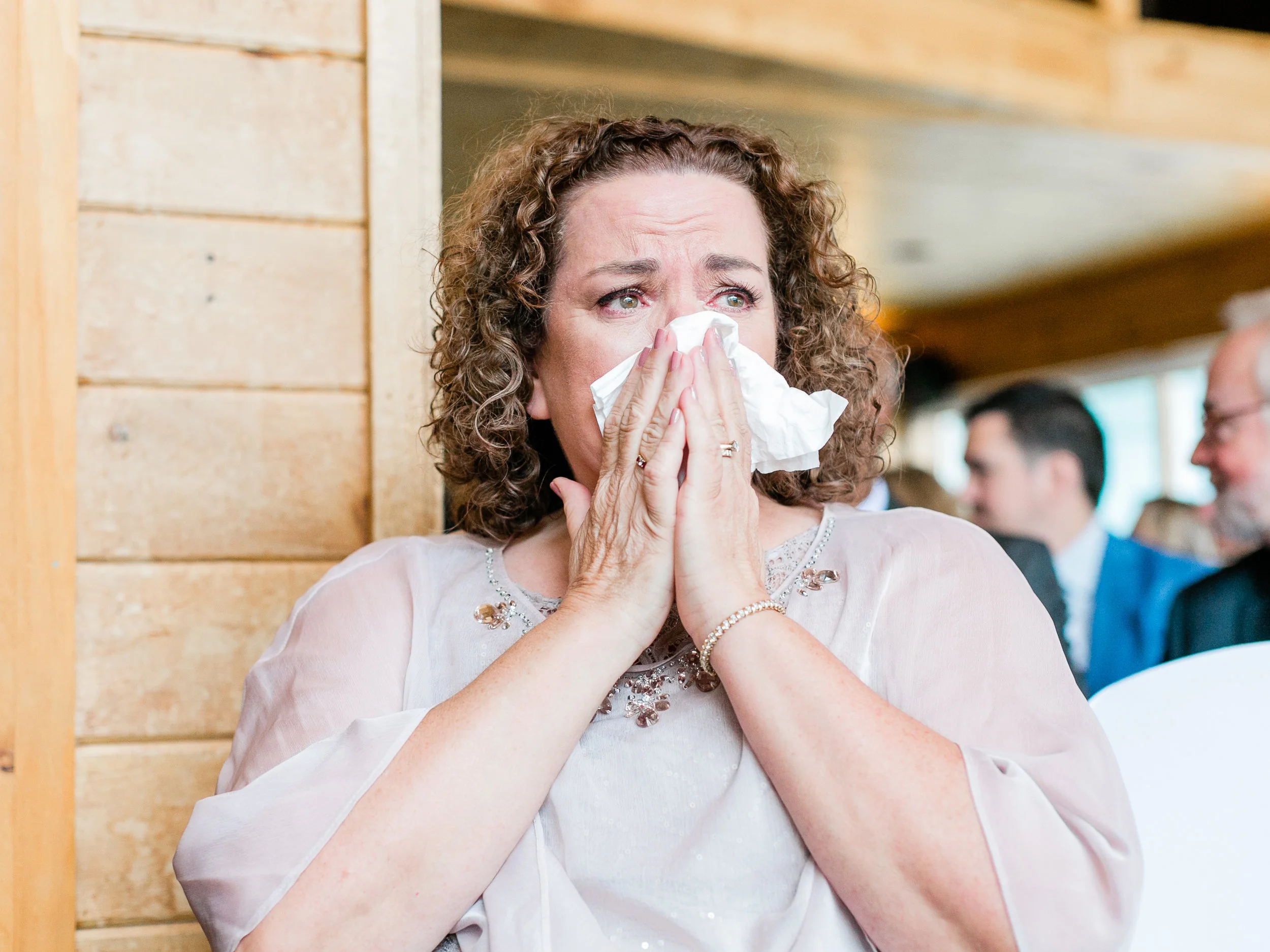 Mother of the bride tearing up as she watches her daughter get married