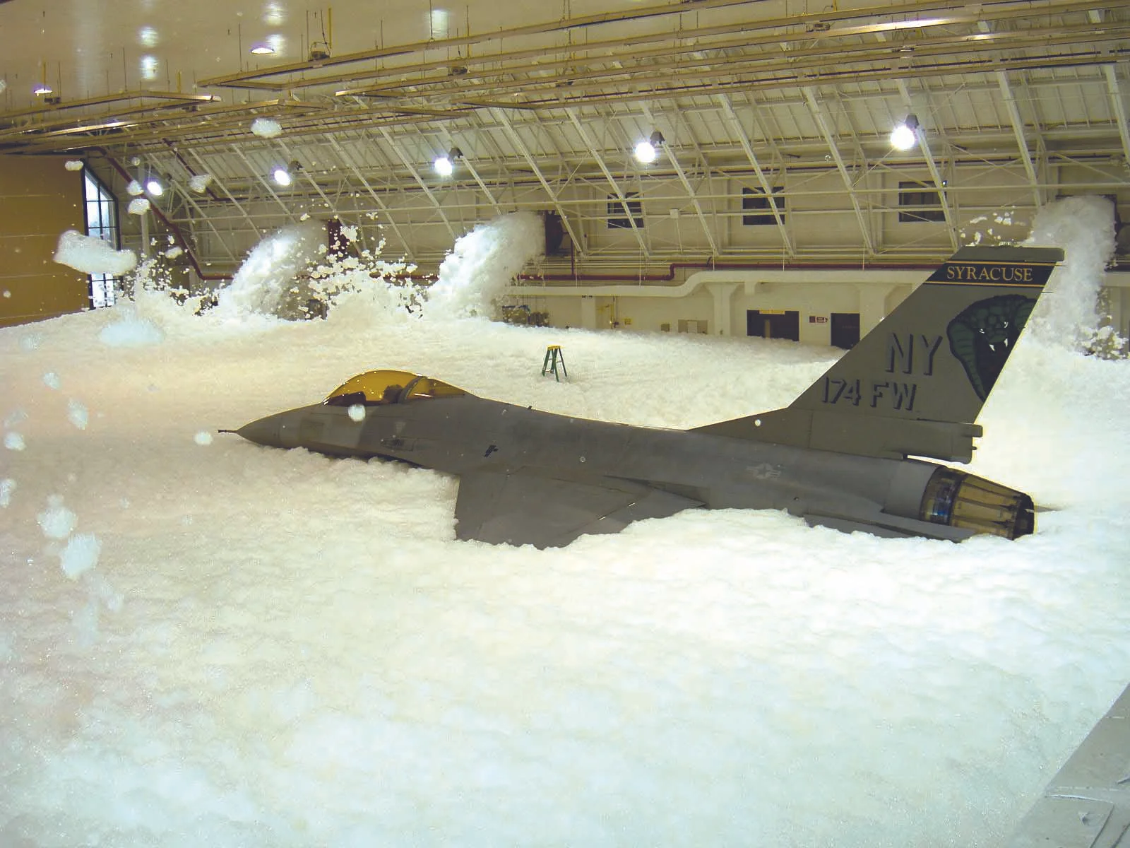Firefighting foam is designed to separate the fire from its oxygen supply. While the military periodically tests hangar “deluge” foam suppression systems, accidental releases from these systems have also occurred, resulting in potential AFFF release into the environment. Source: New York Air National Guard.