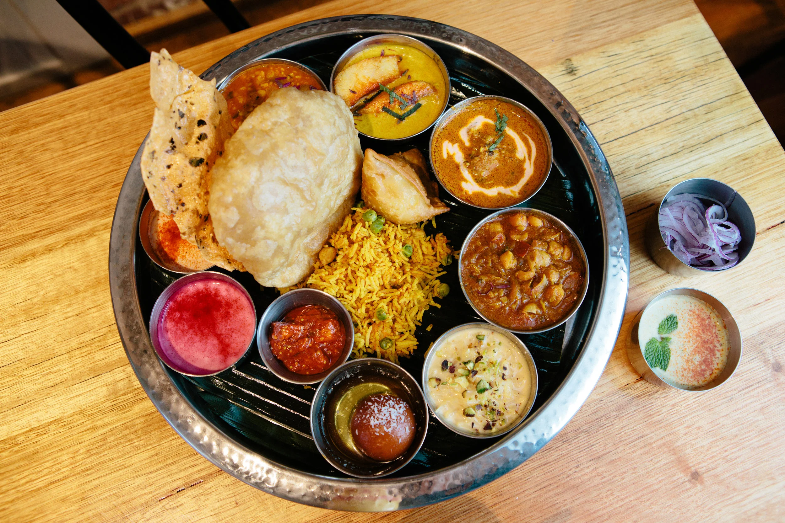 Bhang Thali at Eat Drink Bhang, an Indian restaurant in Brunswick, featuring rice, curries, papadum, samosa, chutneys and dessert.