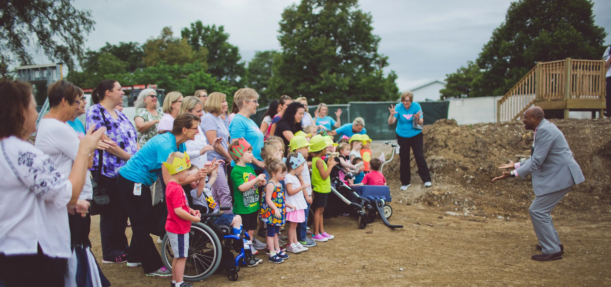 Mark Stoddart, Director of Spiritual Wellness at SMH, leads children from the Lee Ann Britain Infant Development Center and Early Learning Center in a song and blessing as the beam is lifted into the air.