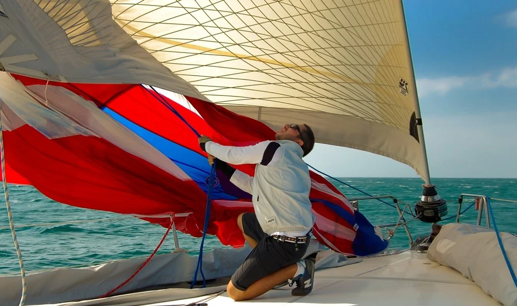 Using a dousing sock allows one person to douse the spinnaker. Without the sock several crew members would have to wrestle the sail to the deck. This shot shows one person lowering the sock on a 57-footer.