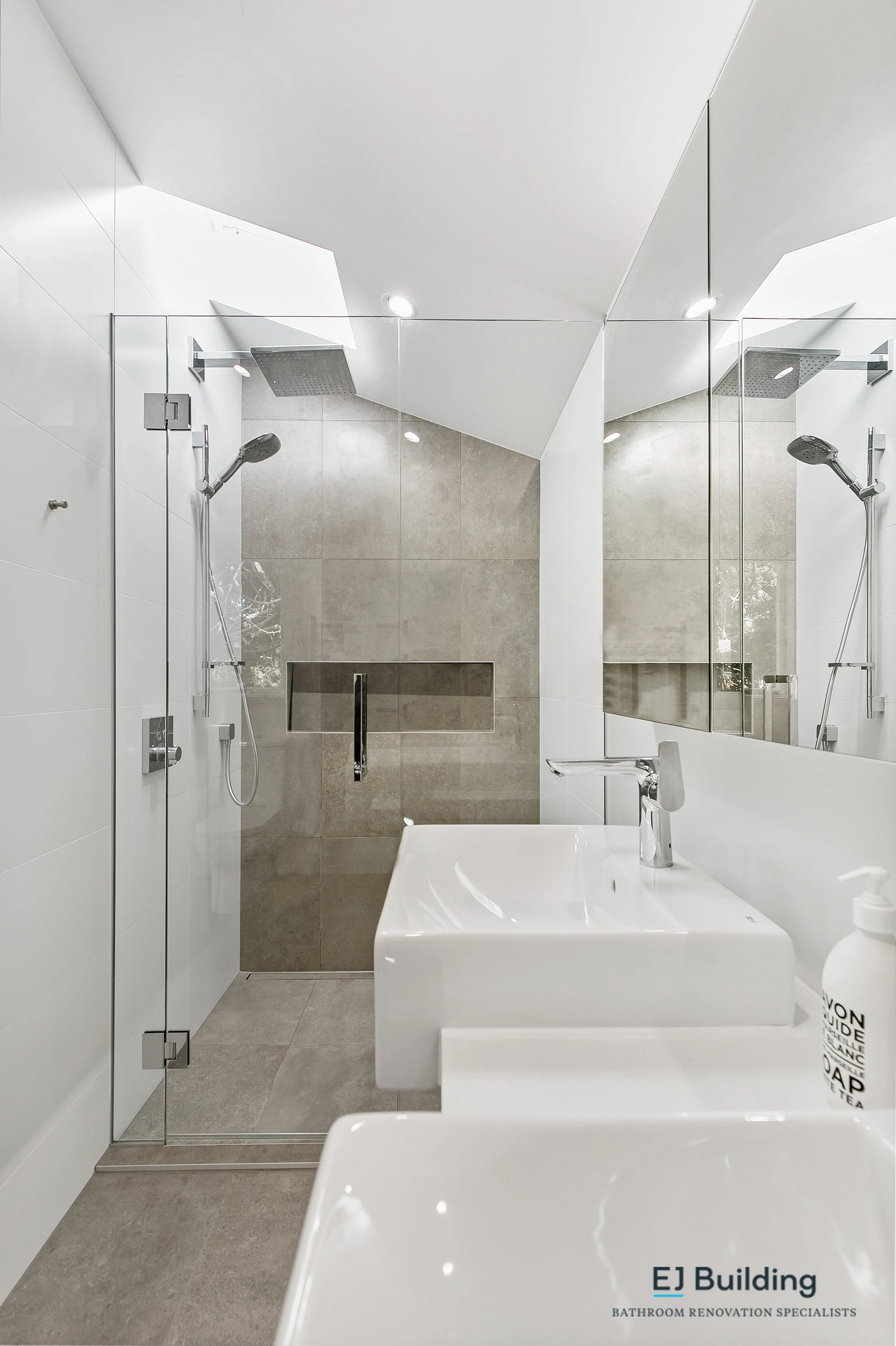 Ellerslie bathroom renovator Auckland. Bathroom renovation ideas with large wall to wall shower and skylight above. Double vanity with matching mirror cabinet . Bathroom Renovation by E J Building Bathroom renovators In Auckland.