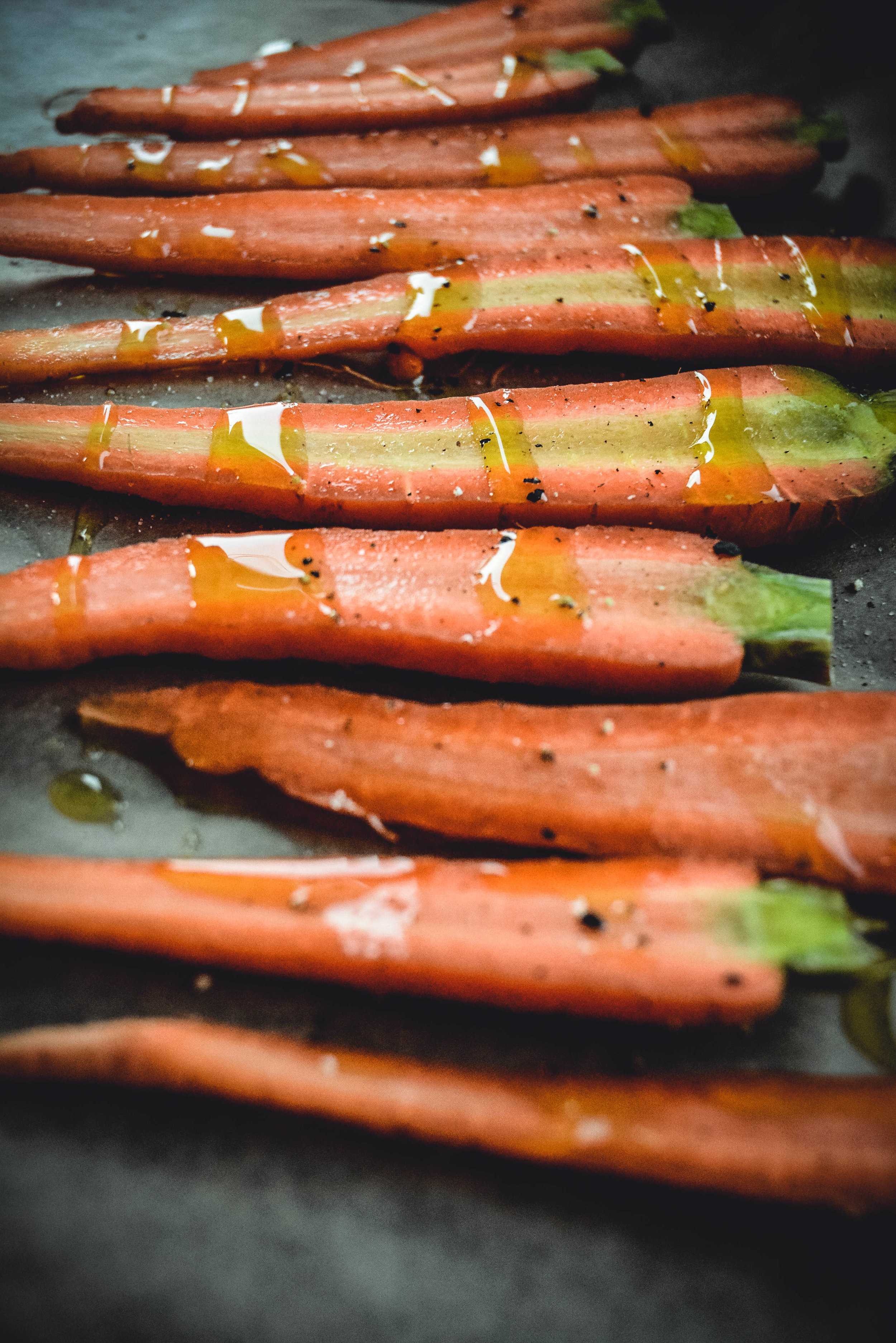 carrots sliced on tray drizzled with olive oil
