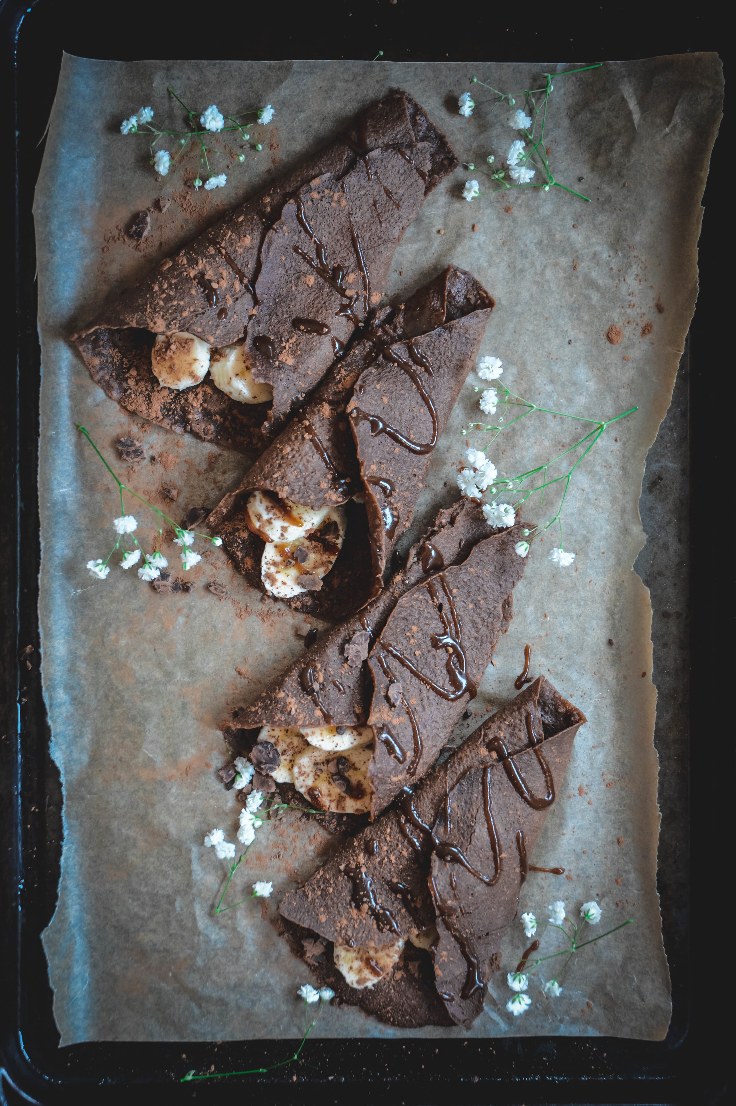 4 paleo chocolate crepes wrapped with bananas and drizzle of caramel 