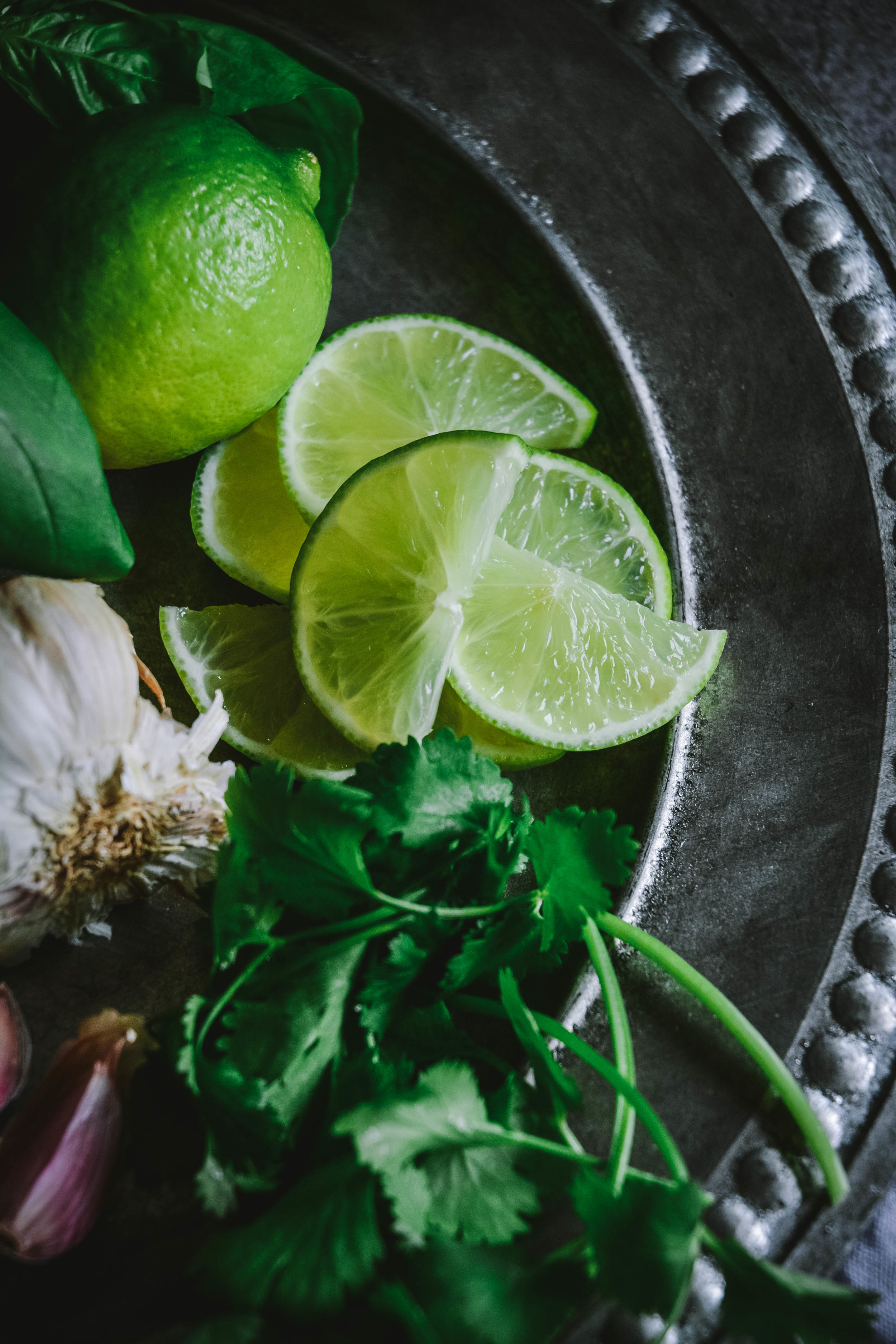 limes, cilantro and garlic on plate