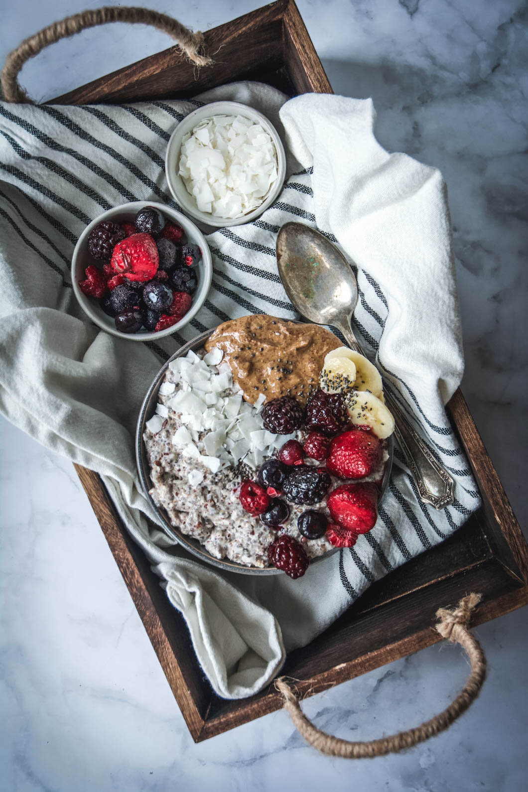  Overnight paleo oatmeal on tray with fruit and coconut flakes, napkin and spoon