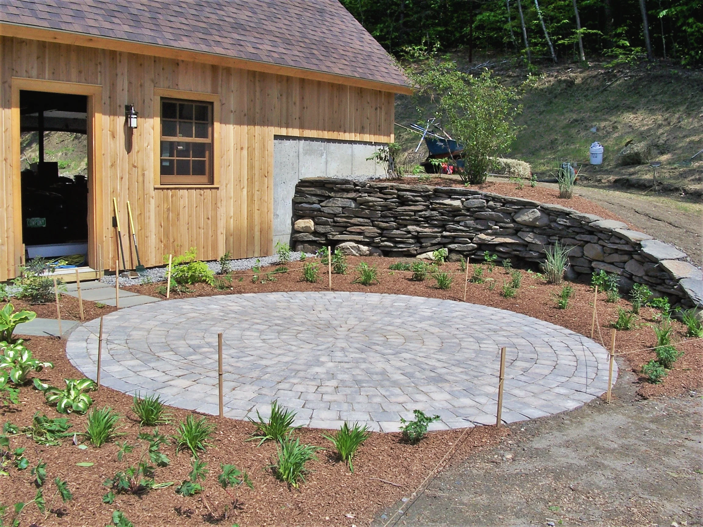 Stone retaining wall, paver patio, flower gardens