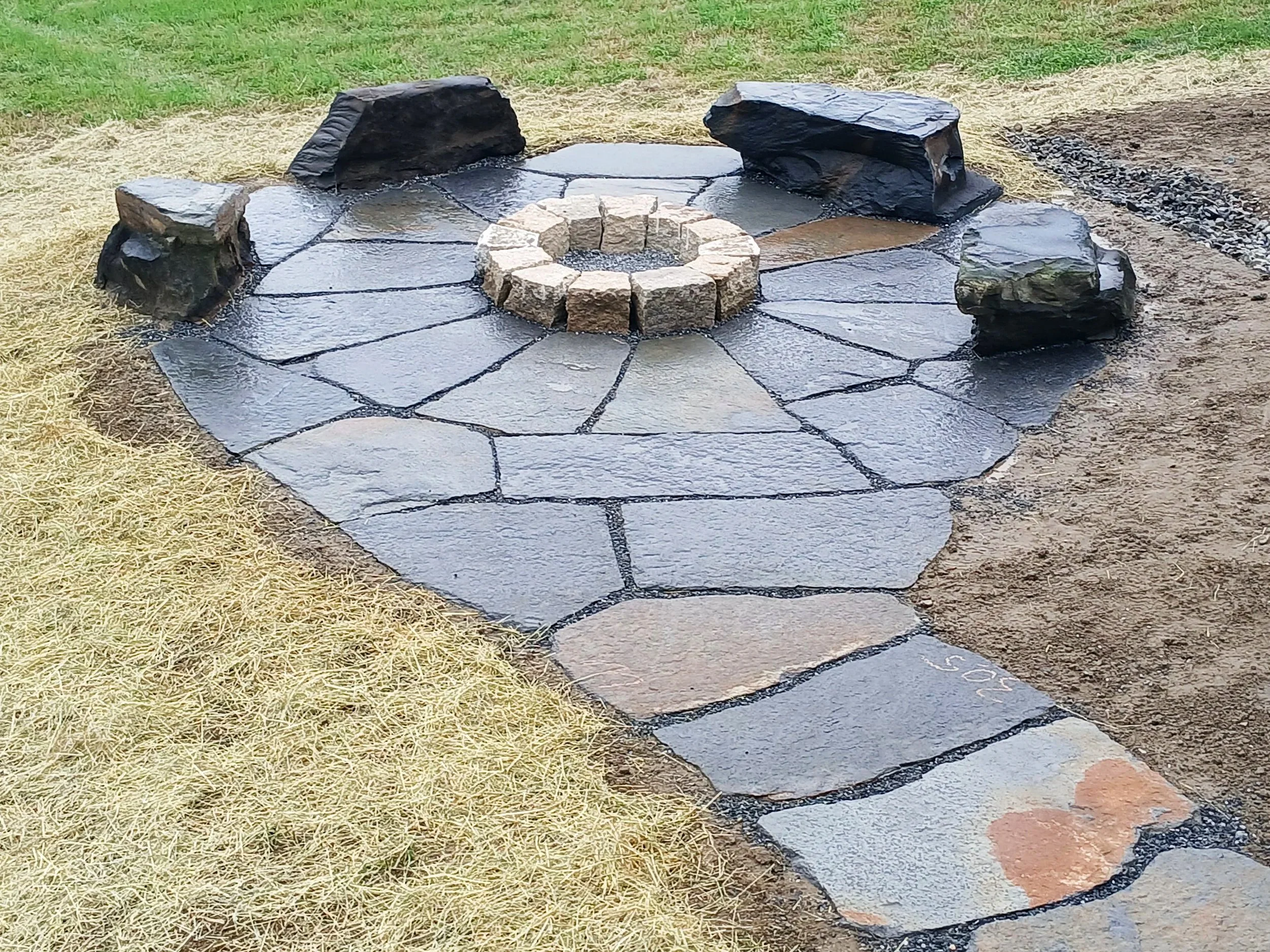 Stone patio with hand split granite fire pit and natural stone benches
