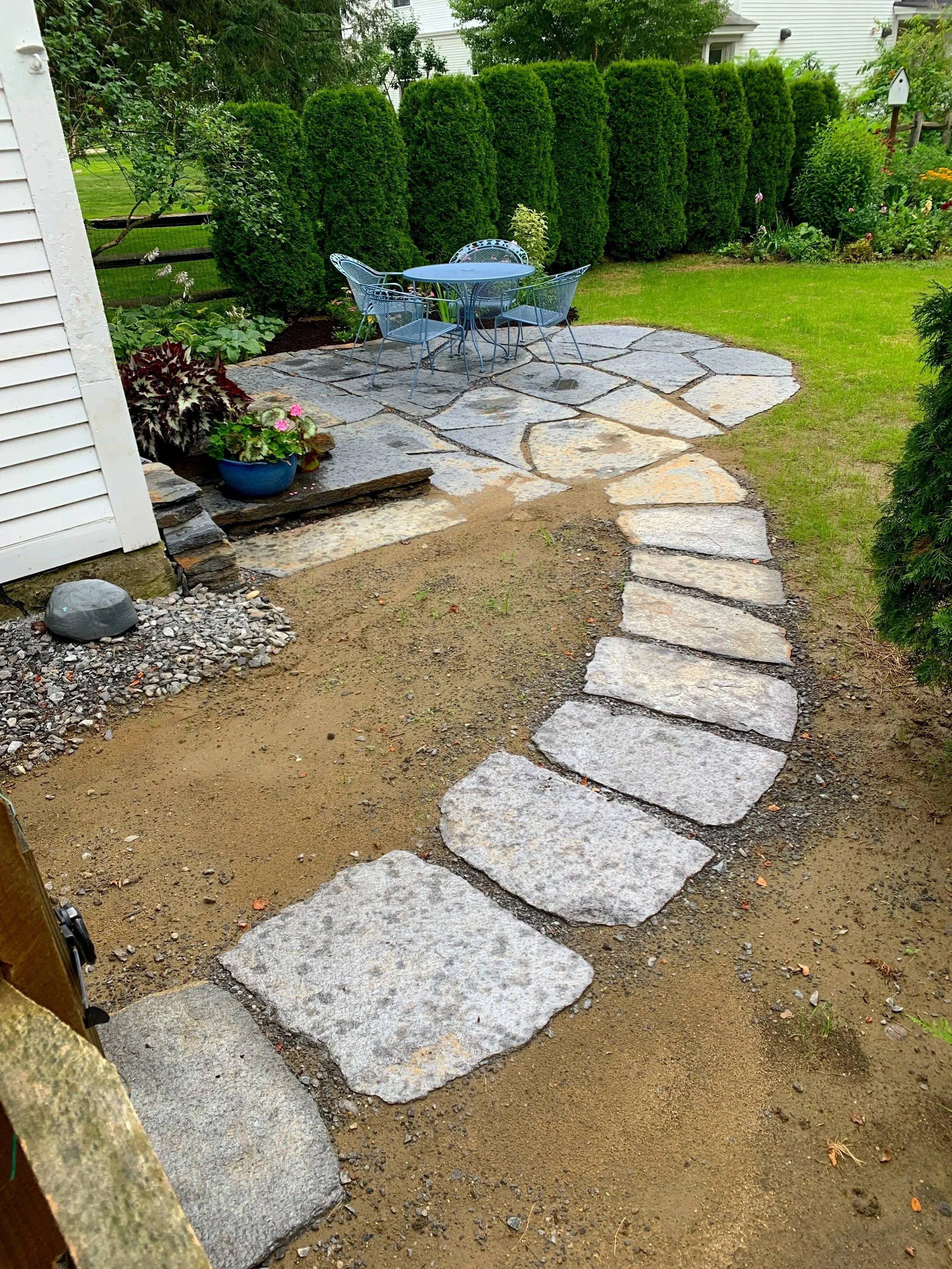 Curving natural stone walkway to sitting patio
