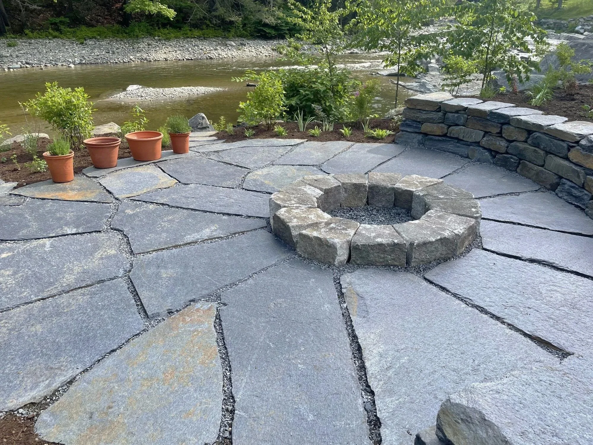 Natural flagstone sitting patio with granite fire pit