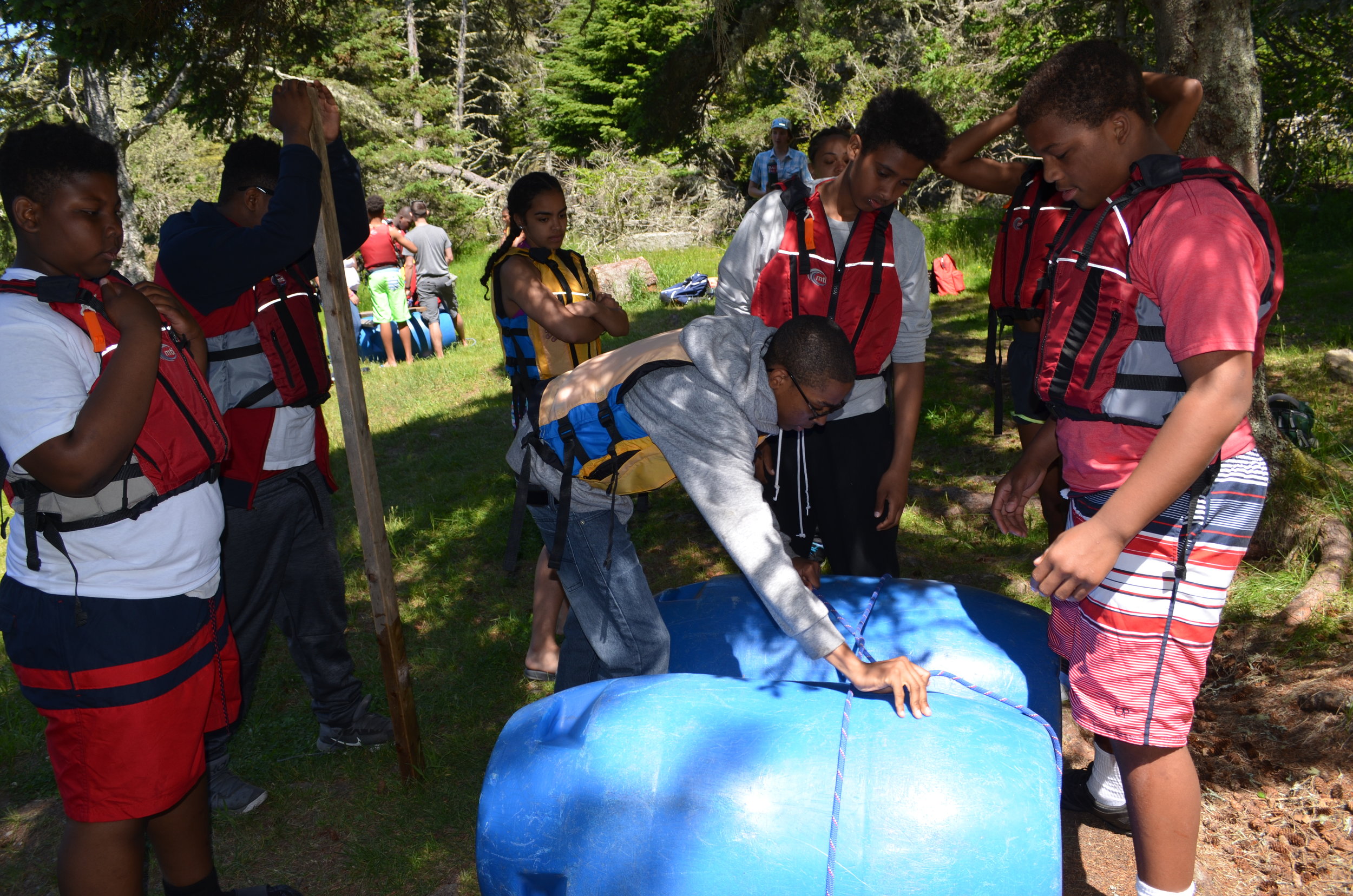   Making a raft out of bamboo, plastic jugs, and rope  