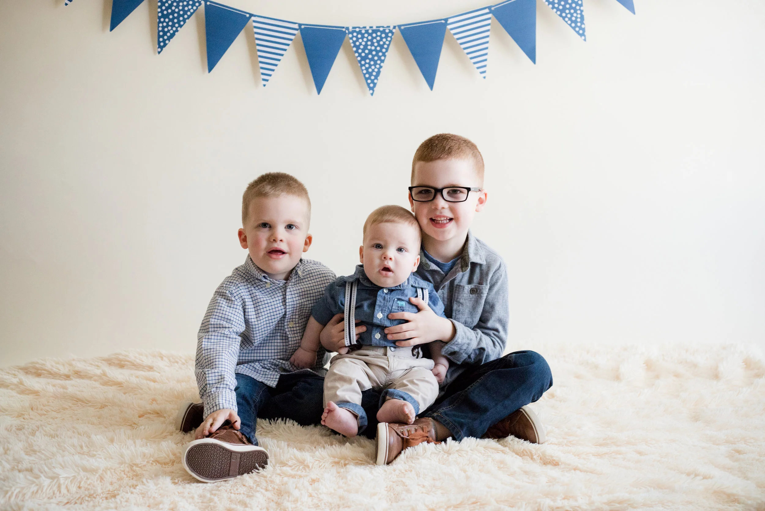 Three boys sitting during indoor photo session. 