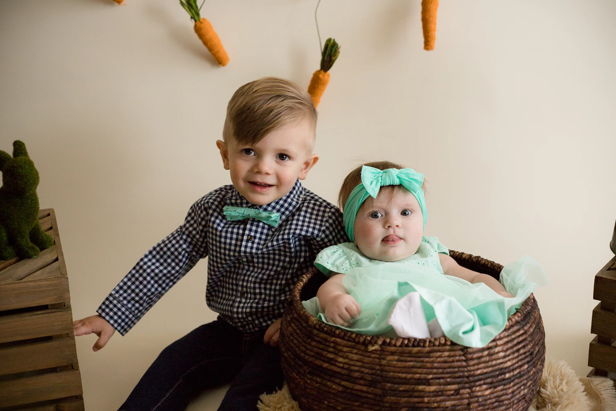 Boy and baby girl children sitting for Easter Mini Session photo in Cedar Rapids, Iowa. 