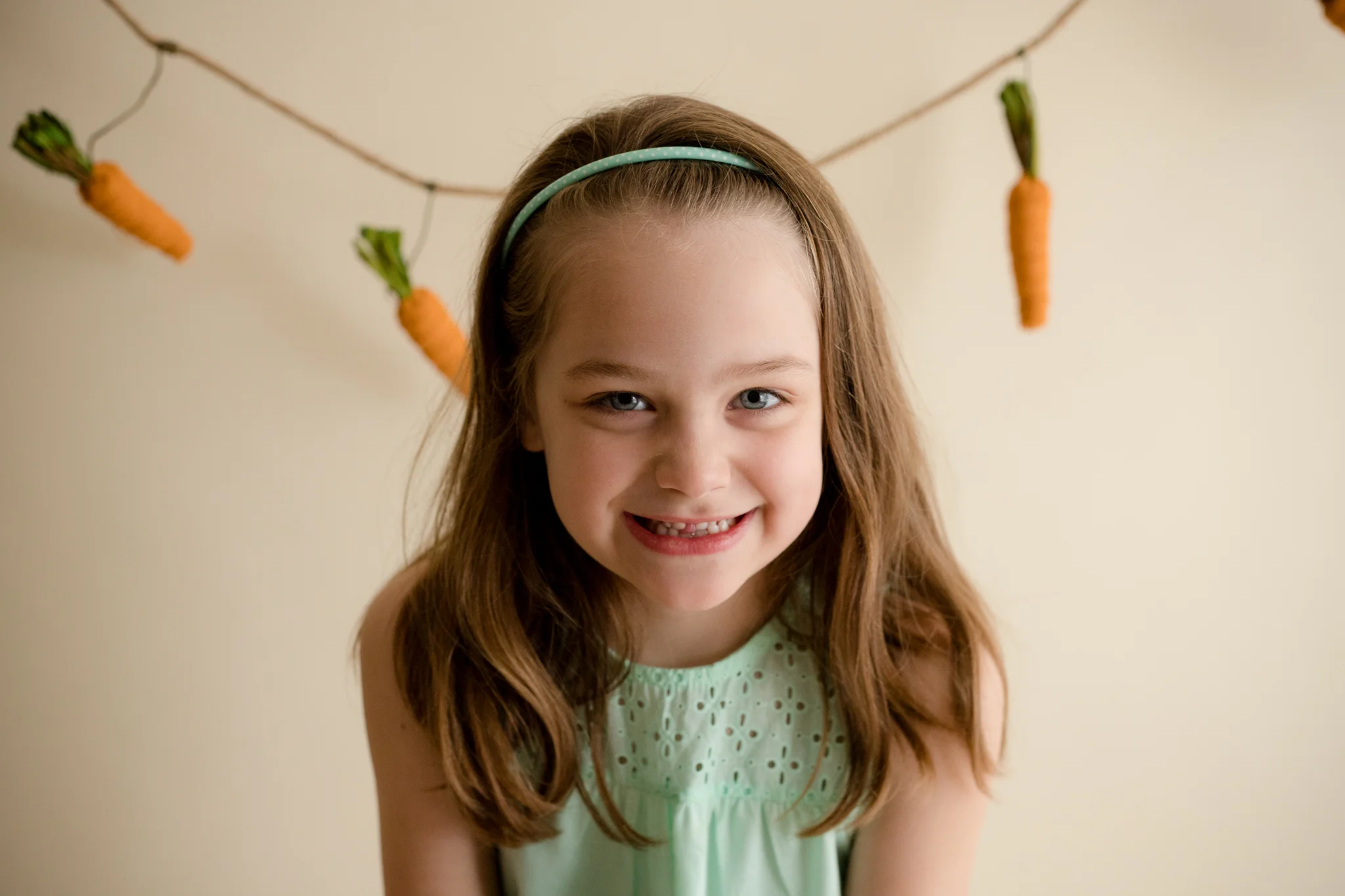 Five year old girl sitting and smiling during Easter Mini Session in Cedar Rapids, Iowa. 
