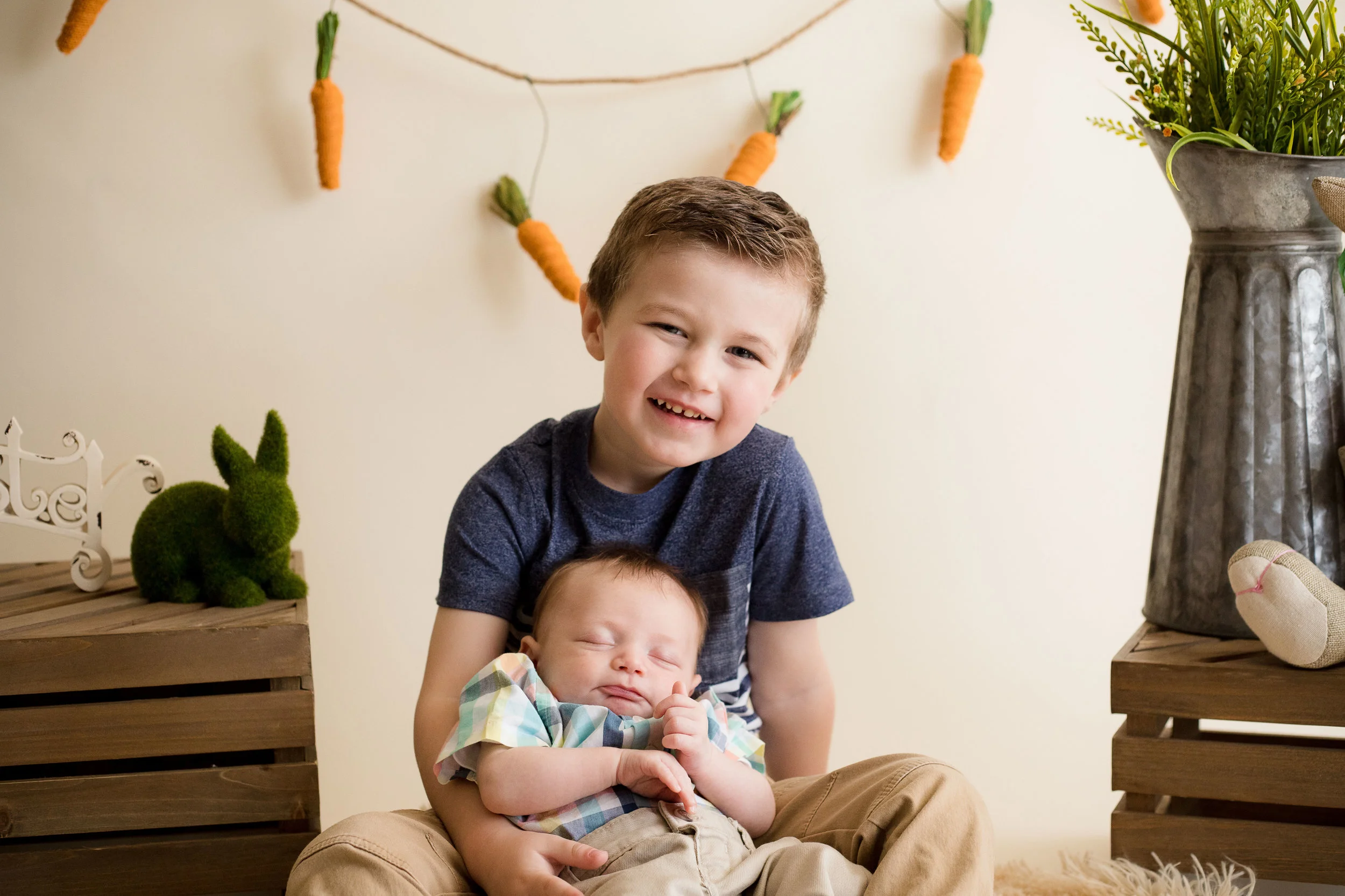 Five year old boy holding newborn baby during Easter Mini Session in Cedar Rapids, Iowa.