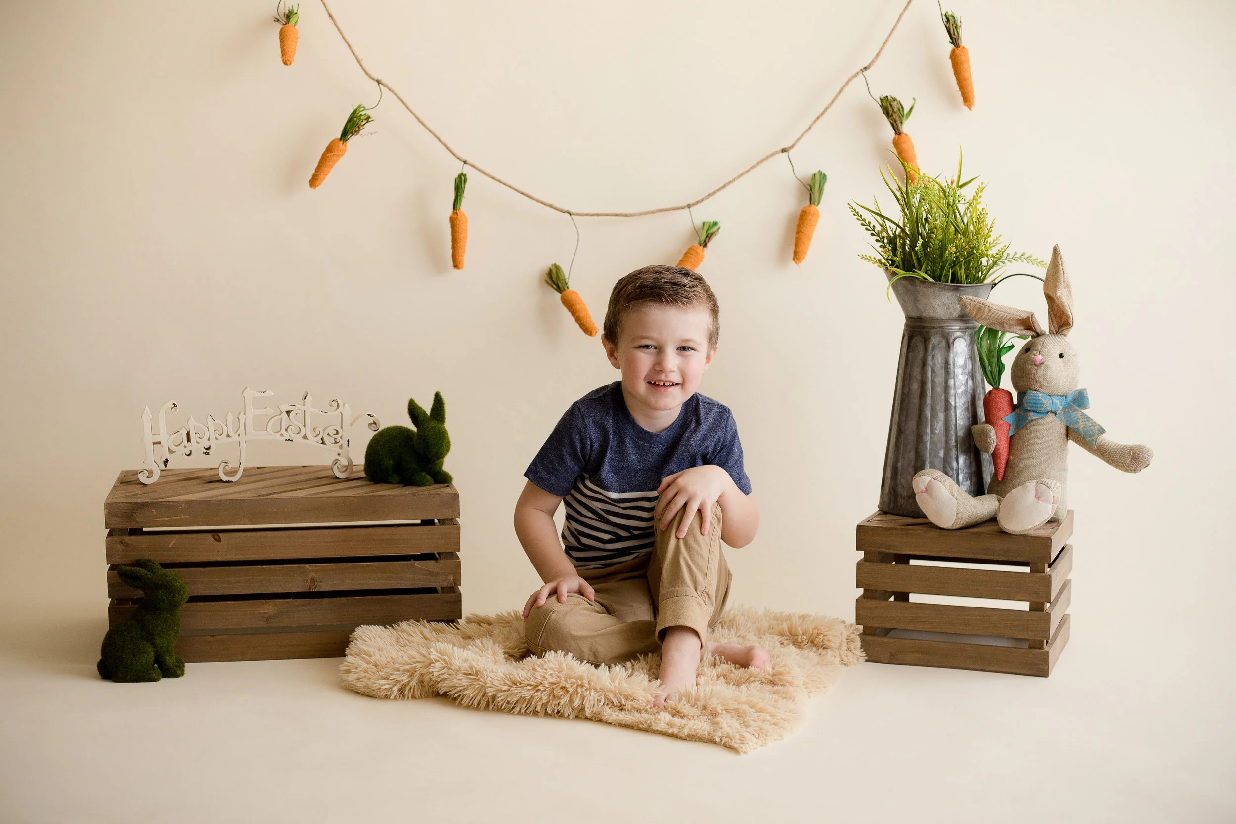 Five year old boy sitting and smiling for a photo during indoor photo session in Cedar Rapids. 