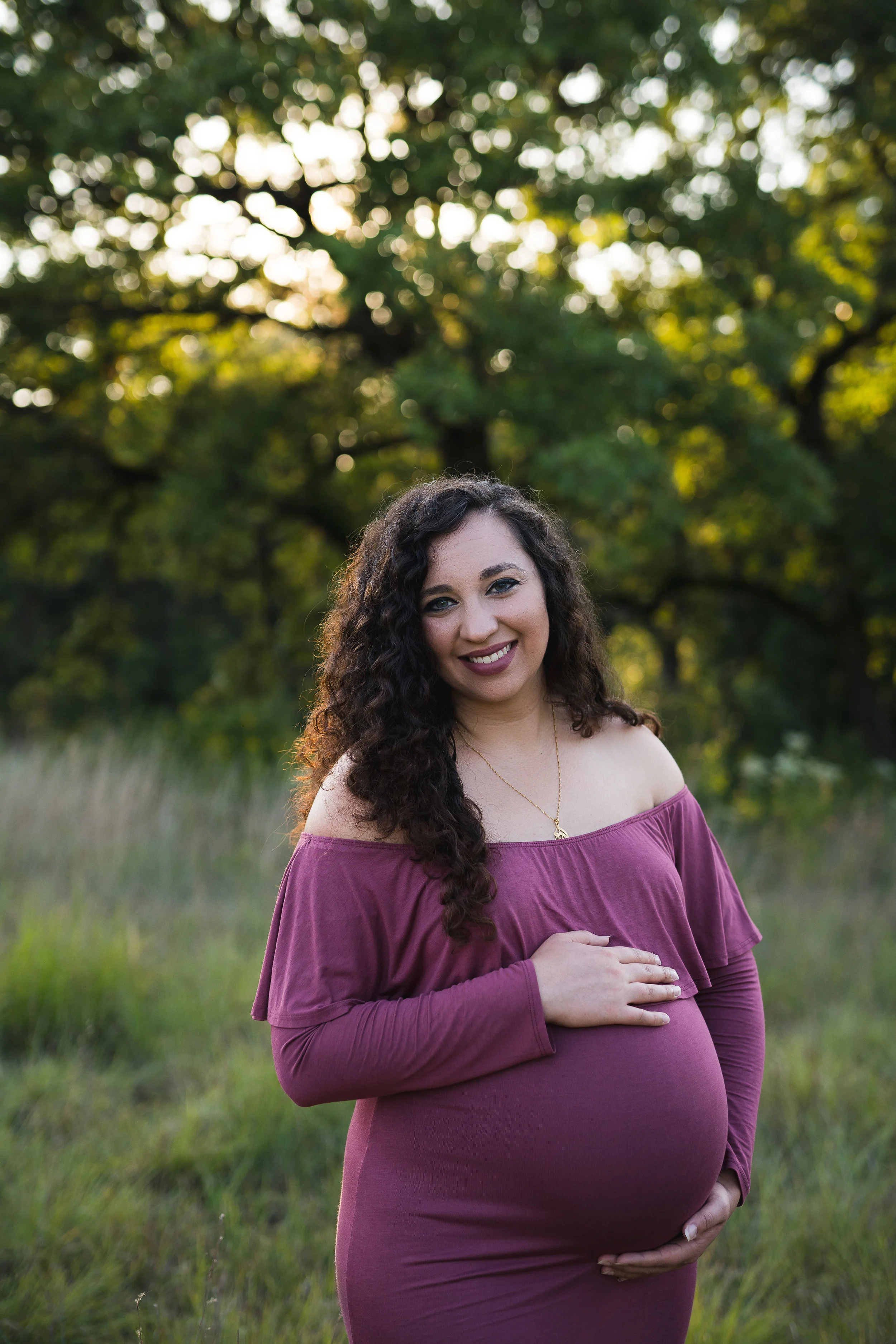 Expecting mother holding her belly during a maternity photo session with Laura Anne Photography in Cedar Rapids, Iowa.