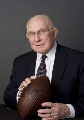 YA Tittle in a suit holding a football