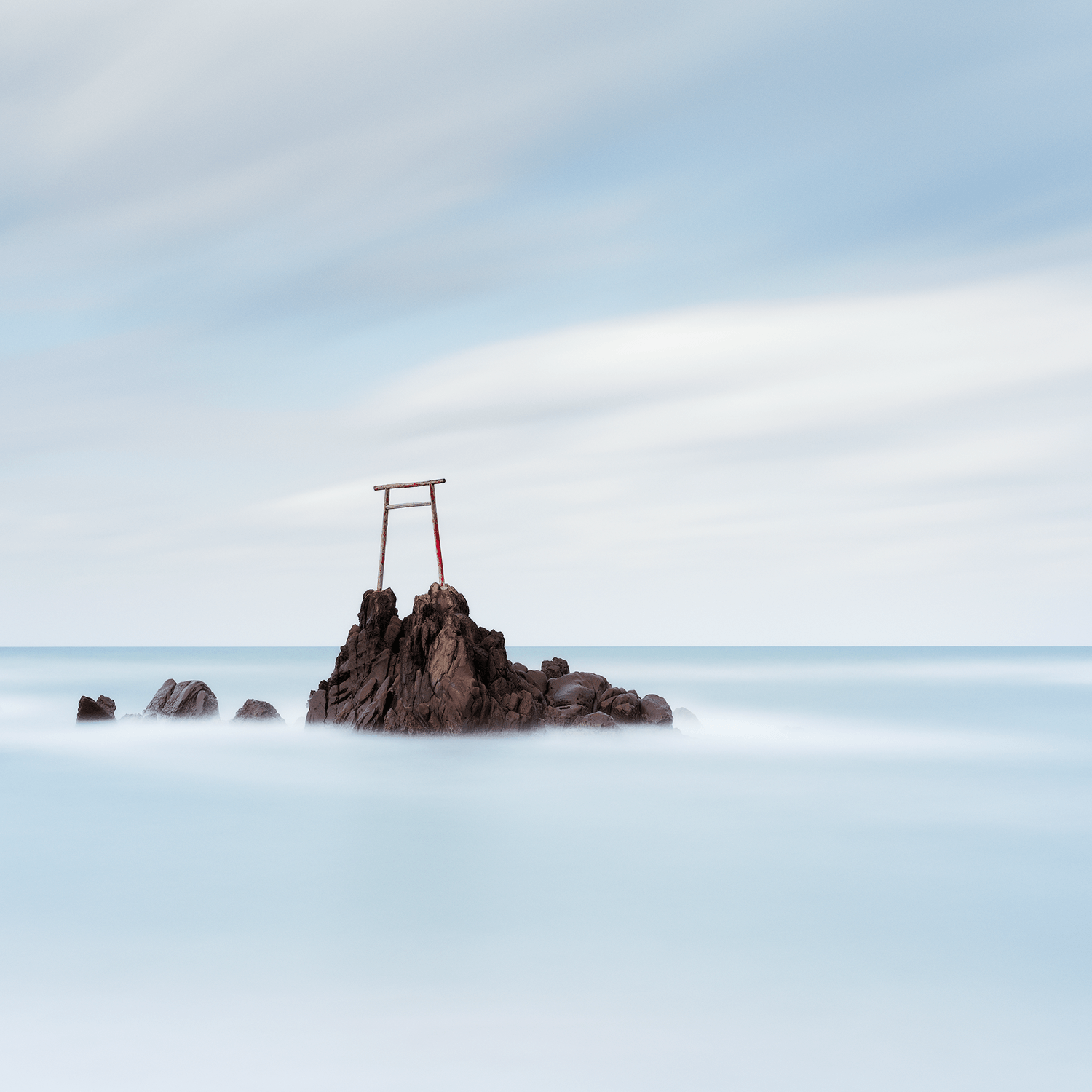 stillness-speaks-passing-clouds-torii-gate-rocks-smooth-water.png