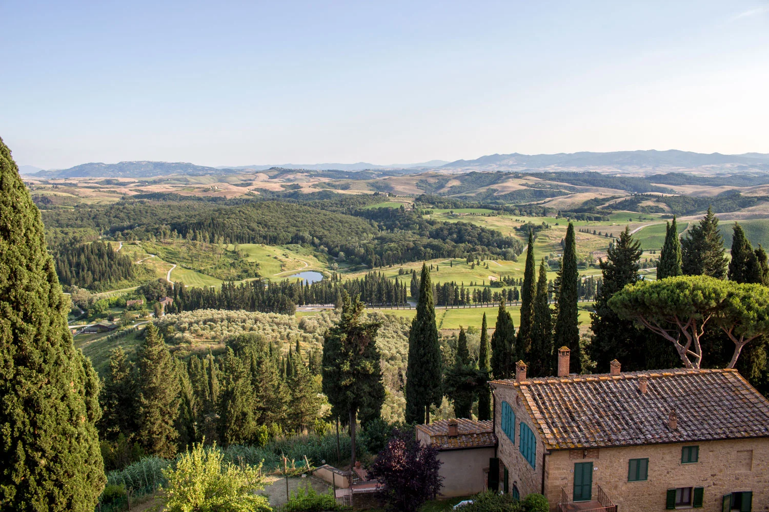 A view of Tuscany, overlooking rolling hills, winding roads and centuries-old vineyards as the warm sun shines down on Castelfalfi, Italy.