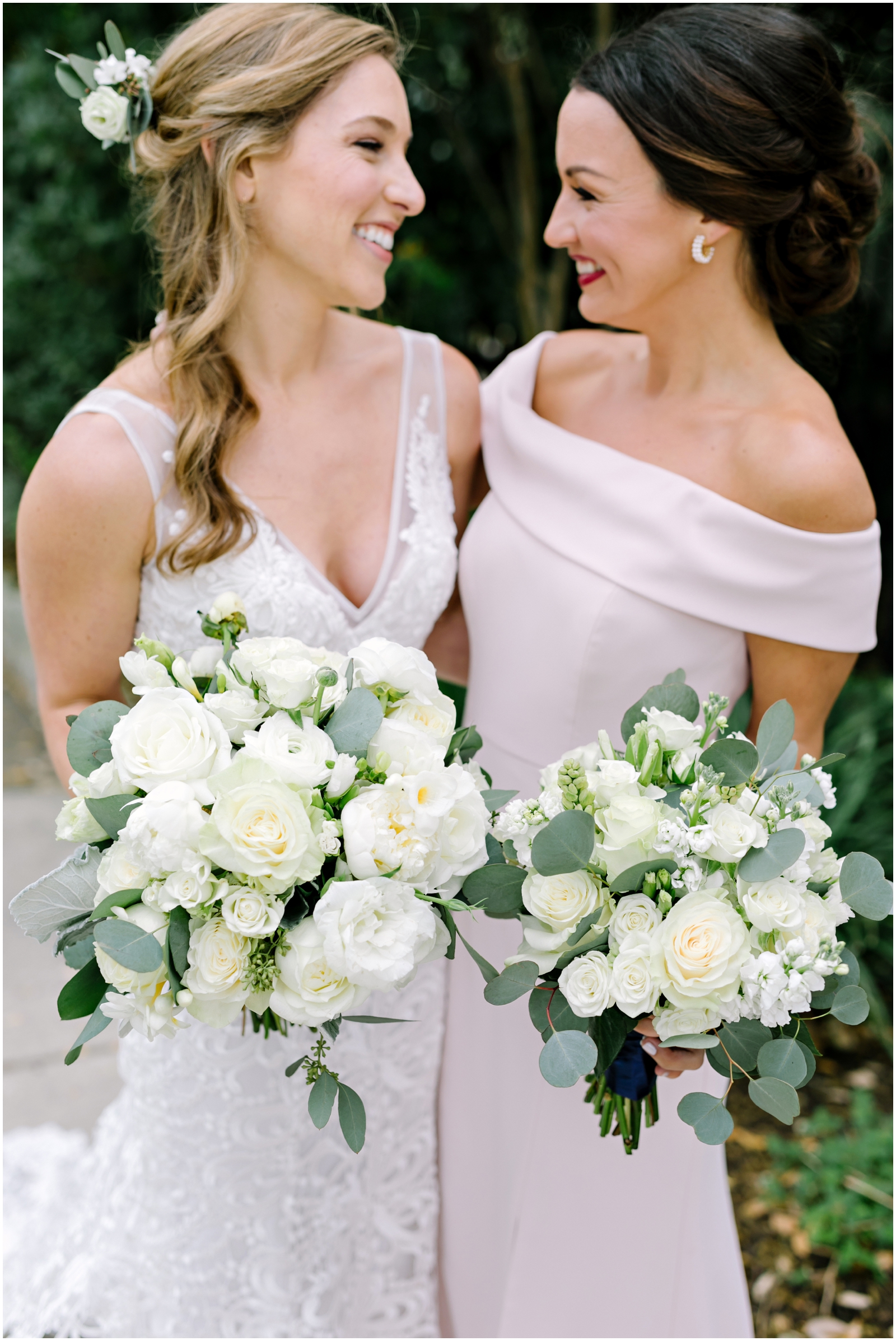 Bride and bridesmaids holding white and greenery wedding bouquet