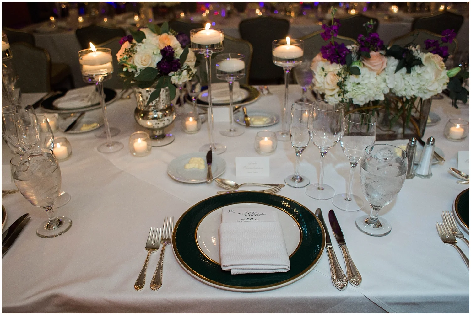 wedding reception table setting with candles and floral decor