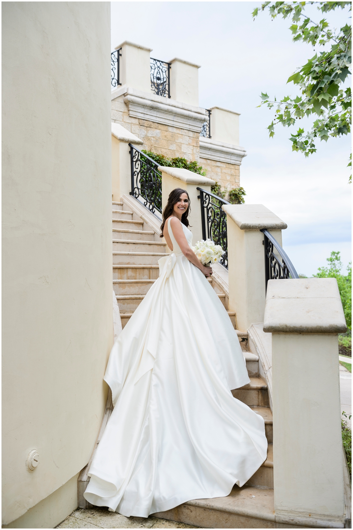  bride posing at a grand stairwell 