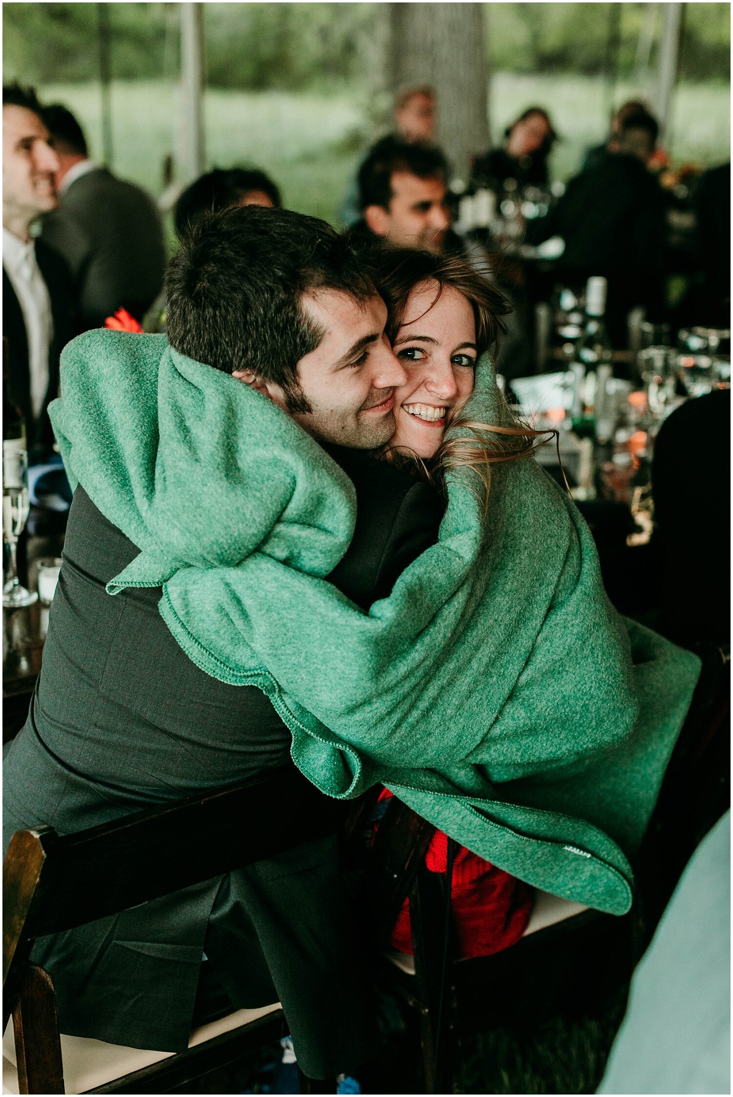  wedding guests using the blankets to keep them warm 