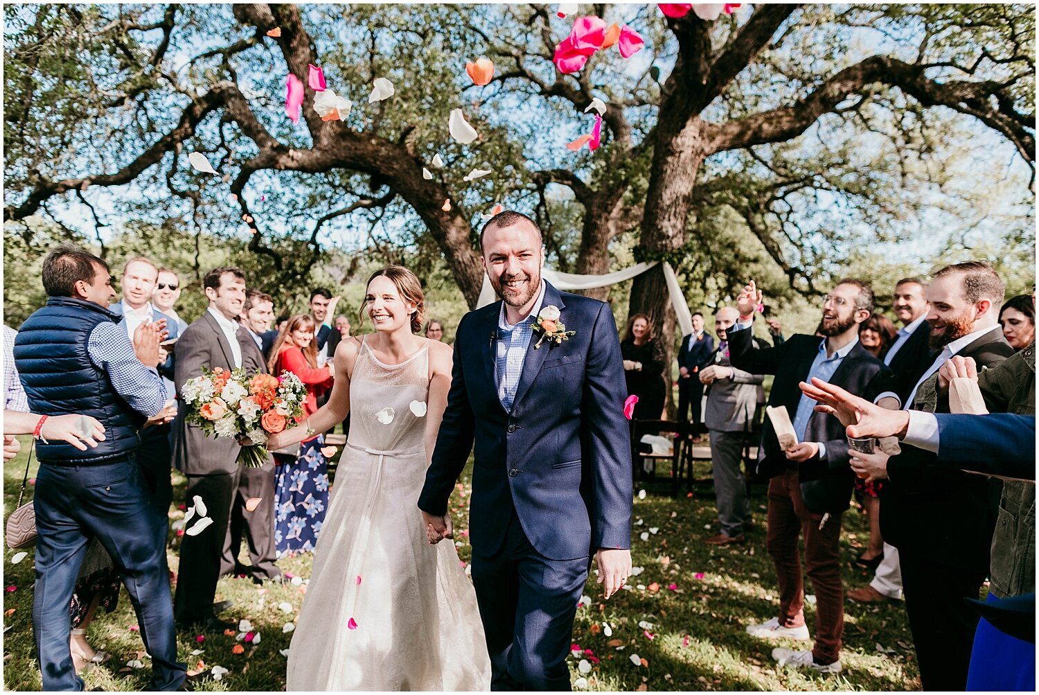  bride and groom exit their wedding ceremony with rose petals being thrown 