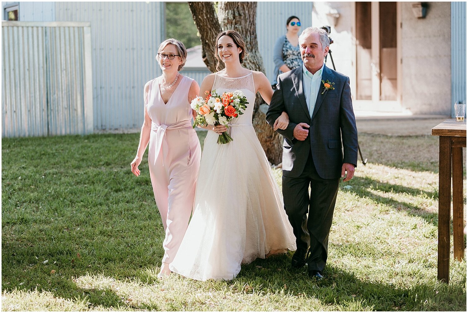  bride and parents walking down the aisle for outdoor wedding ceremony 