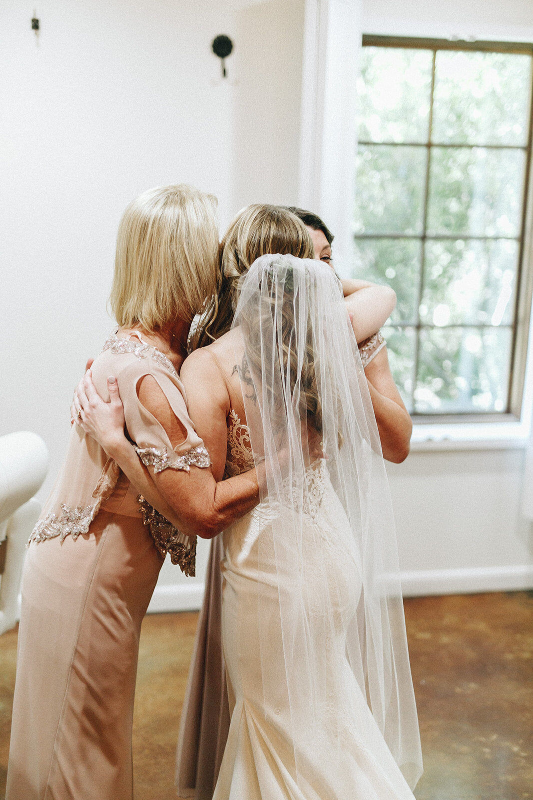  bride hugging her family during their first look 