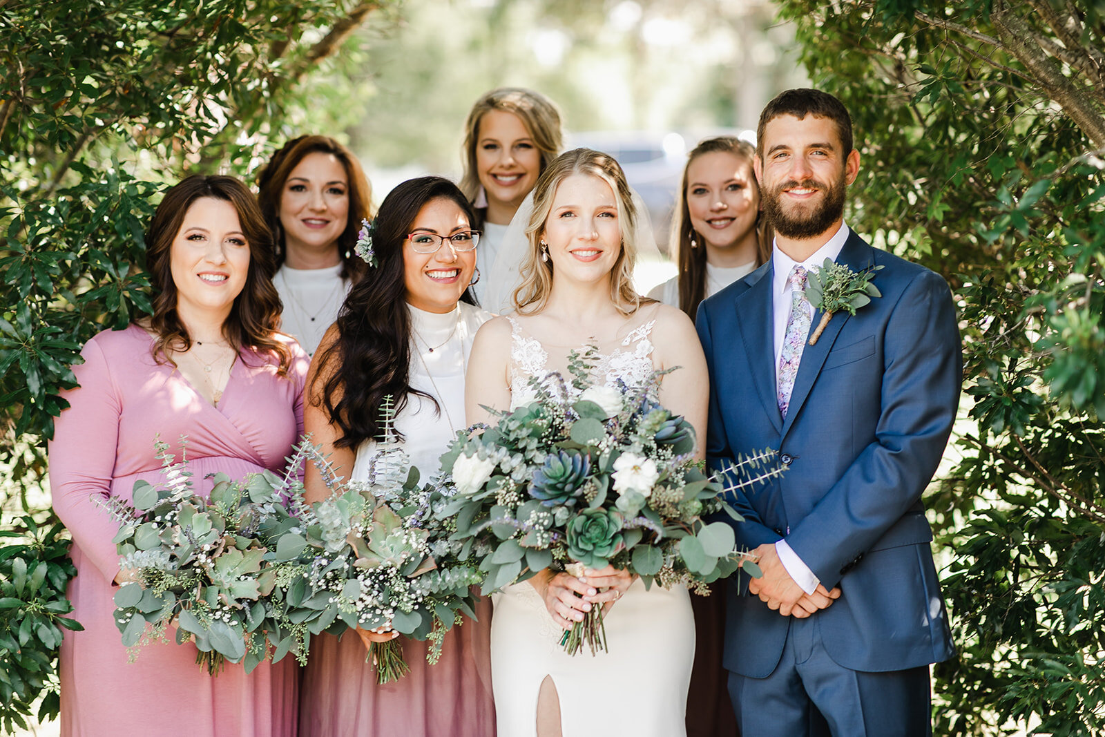  bride and bridesmaids holding their greenery bouquets 
