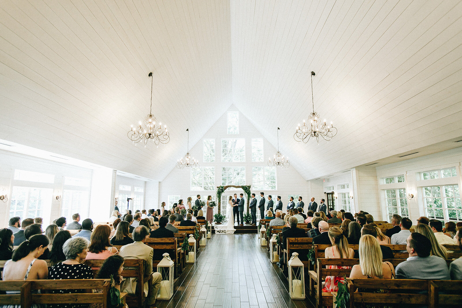  indoor wedding ceremony with greenery decor 