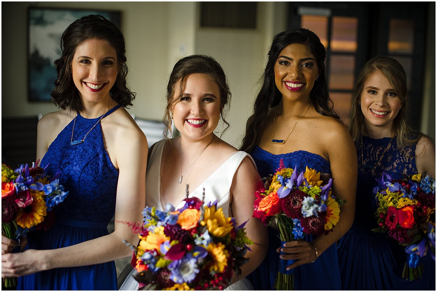  bride and bridesmaids holding their colorful wedding bouquets 