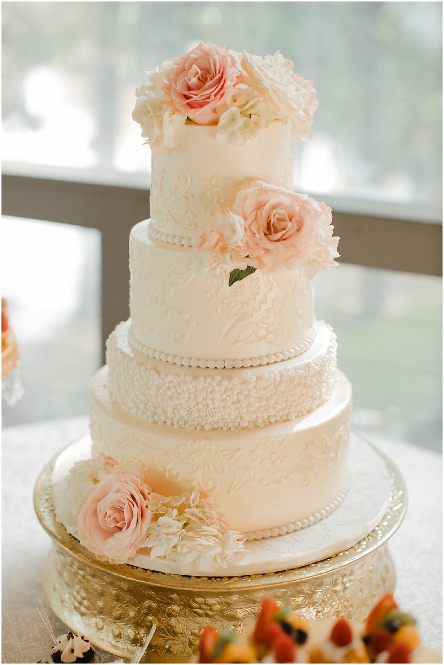  white wedding cake with peach floral decor 