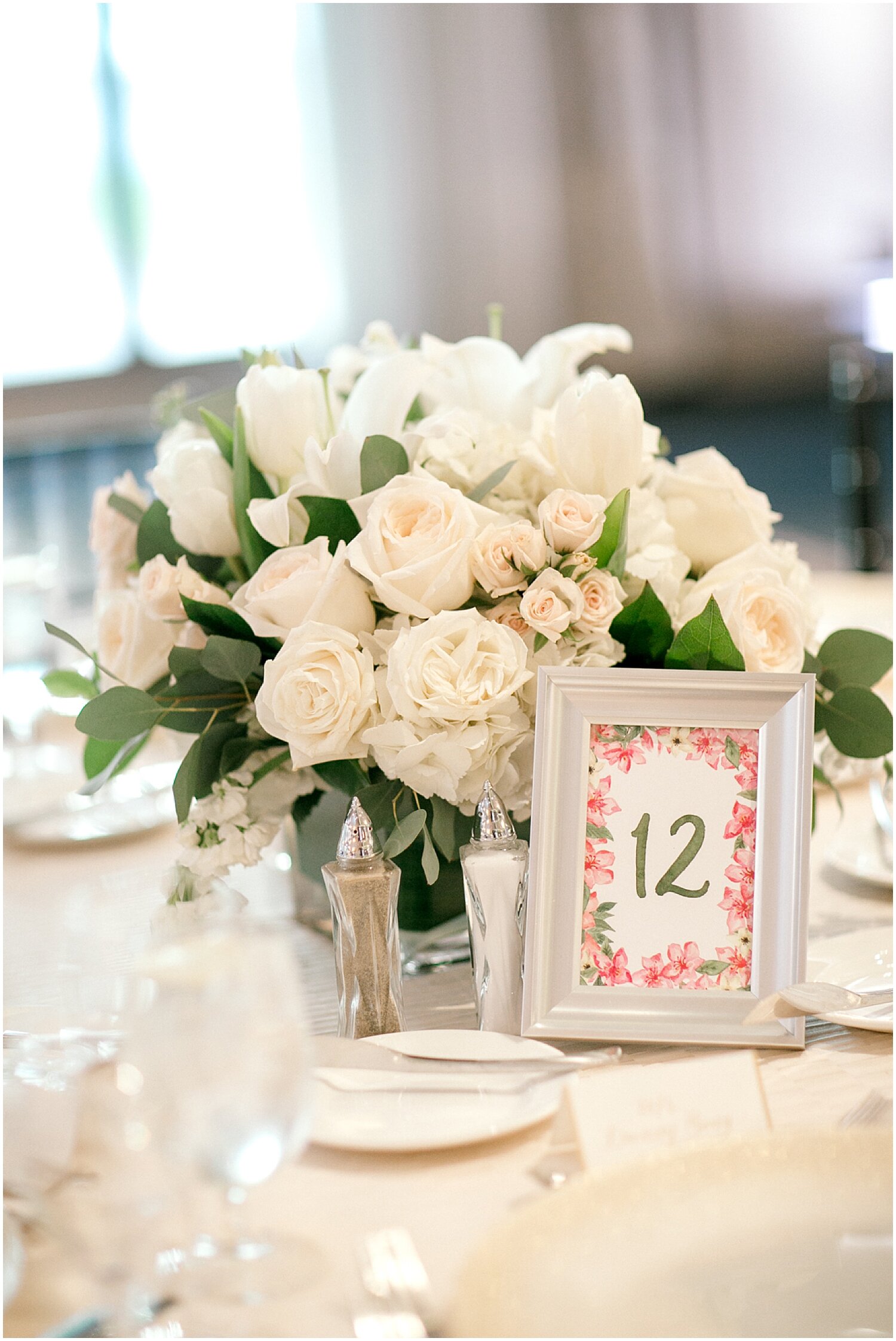  white wedding floral centerpiece and table sign 